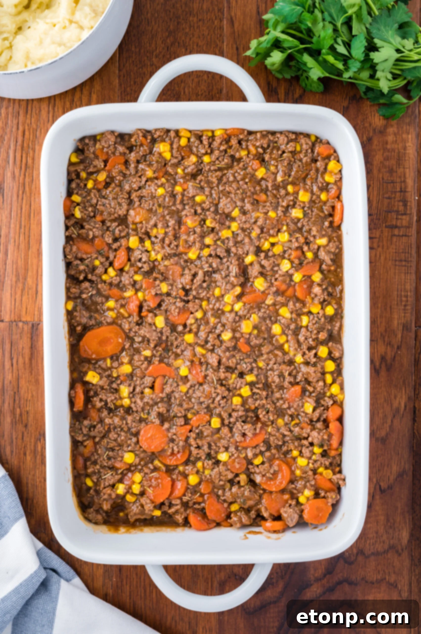 Ground beef browning with chopped onions in a pan.