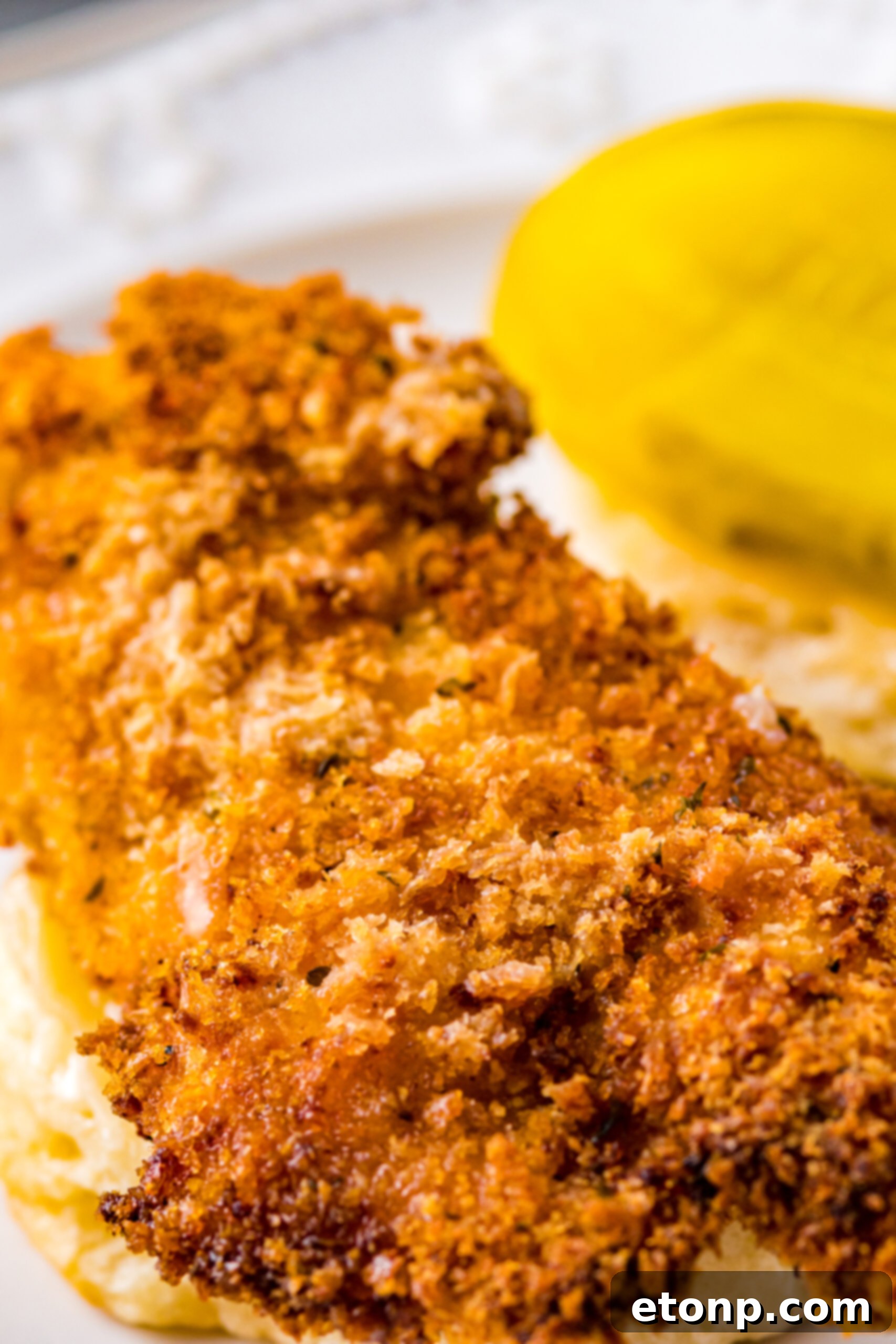 Close-up view of a fully assembled Honey Butter Chicken Biscuit, showing the layers of crispy chicken, honey butter, and fluffy biscuit.