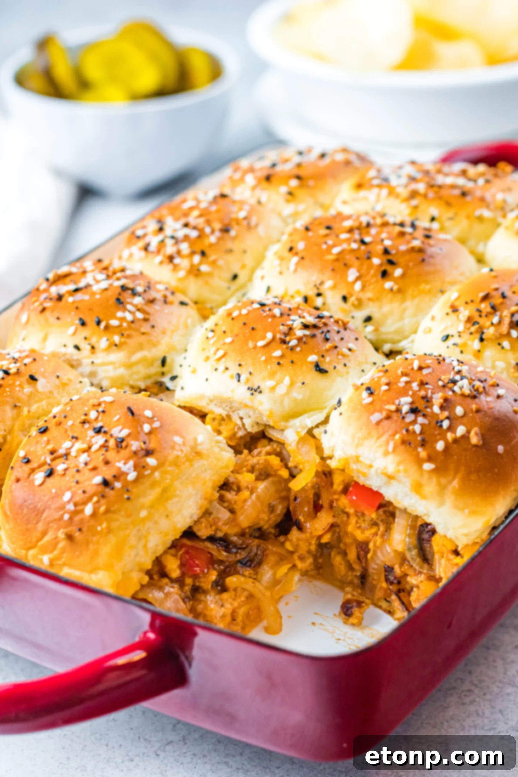 Front view of Cheesy Chicken Sloppy Joe Sliders in a red baking dish.