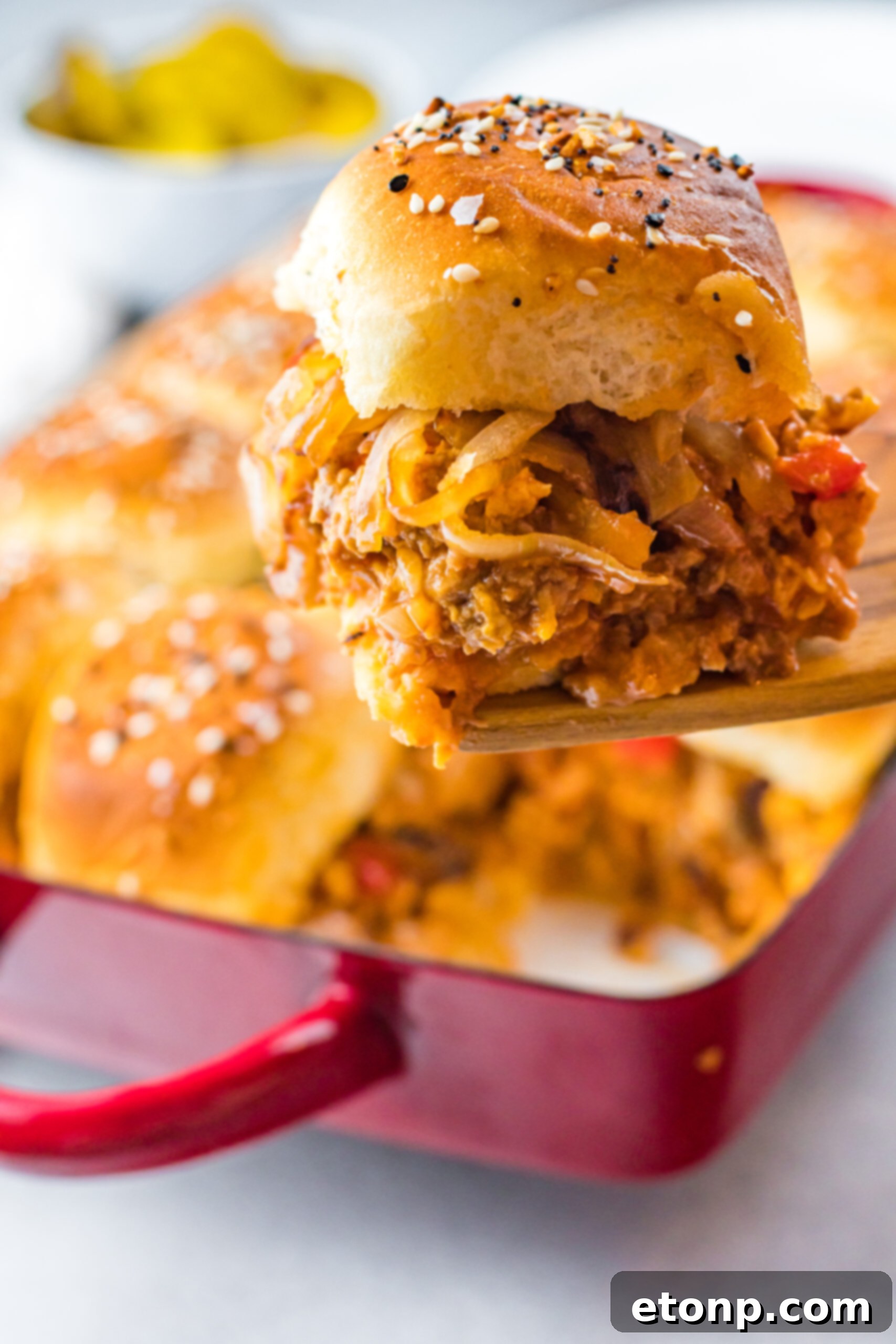 Front view of a Cheesy Chicken Sloppy Joe Slider on a wooden spatula.