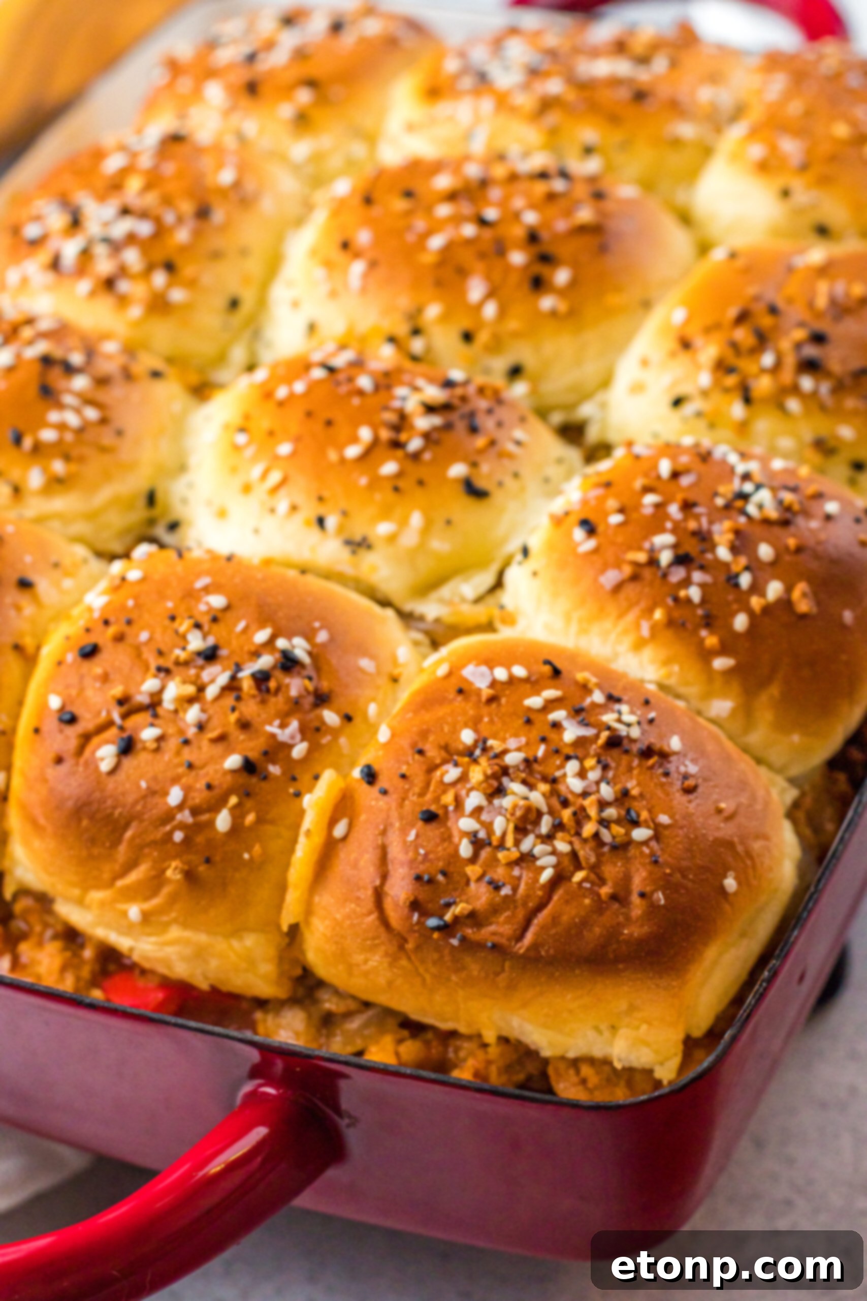 Overhead view of Cheesy Chicken Sloppy Joe Sliders  in a red baking dish.