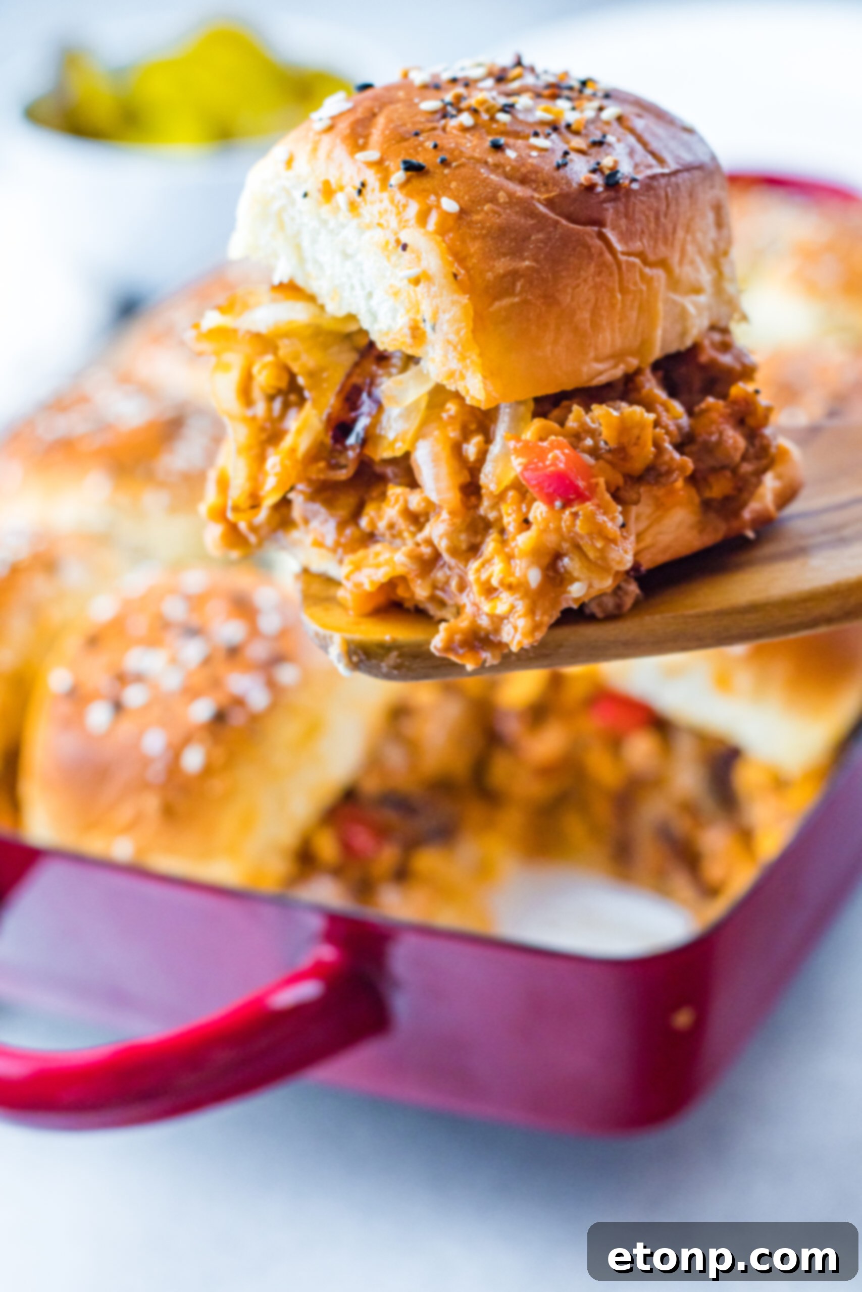 Front view of a Cheesy Chicken Sloppy Joe Slider on a wooden spatula.