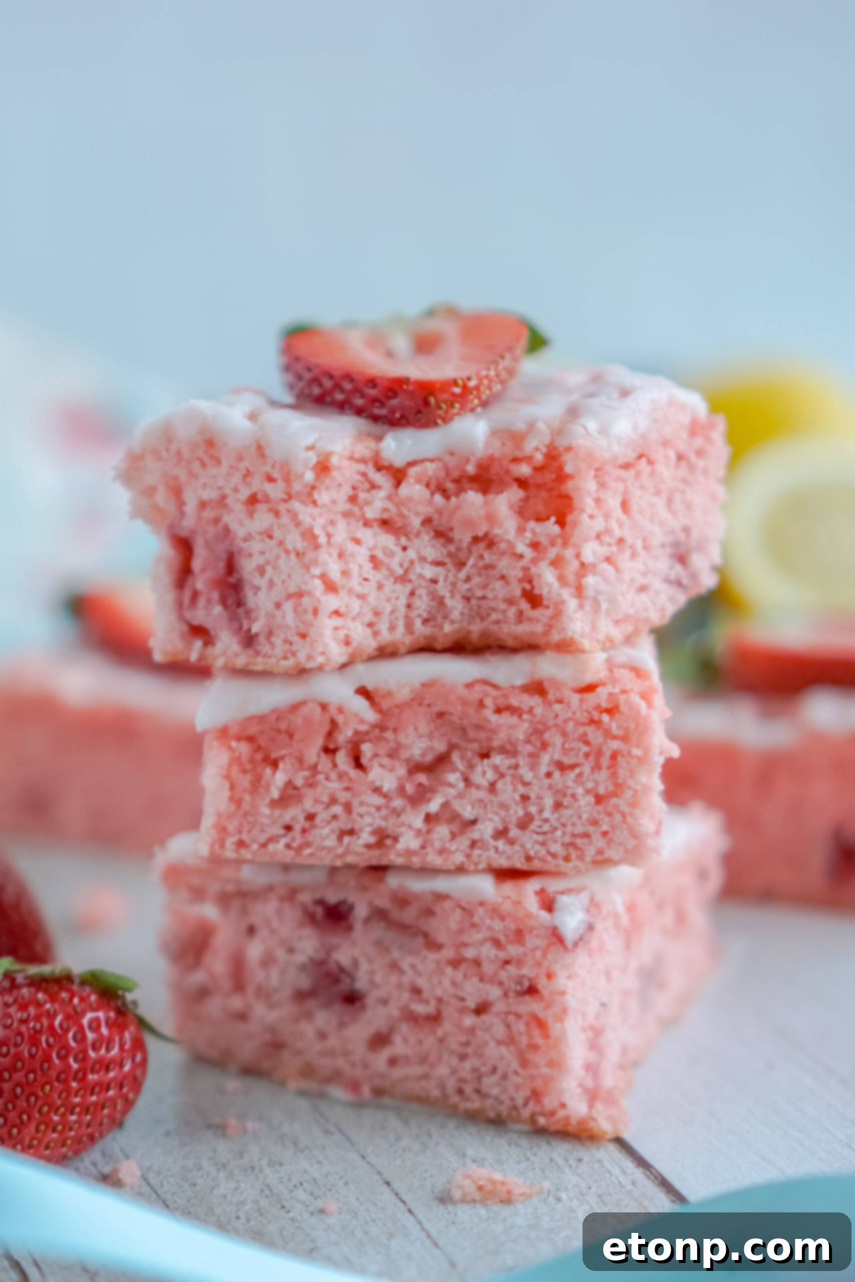 Front view of three Strawberry Lemon Brownies stacked with a bite removed from the top brownie.