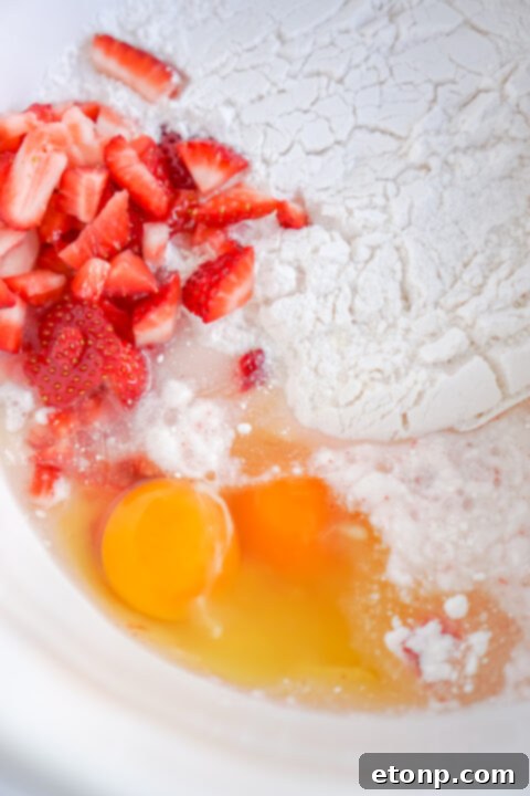 Pouring strawberry brownie batter into a baking dish.