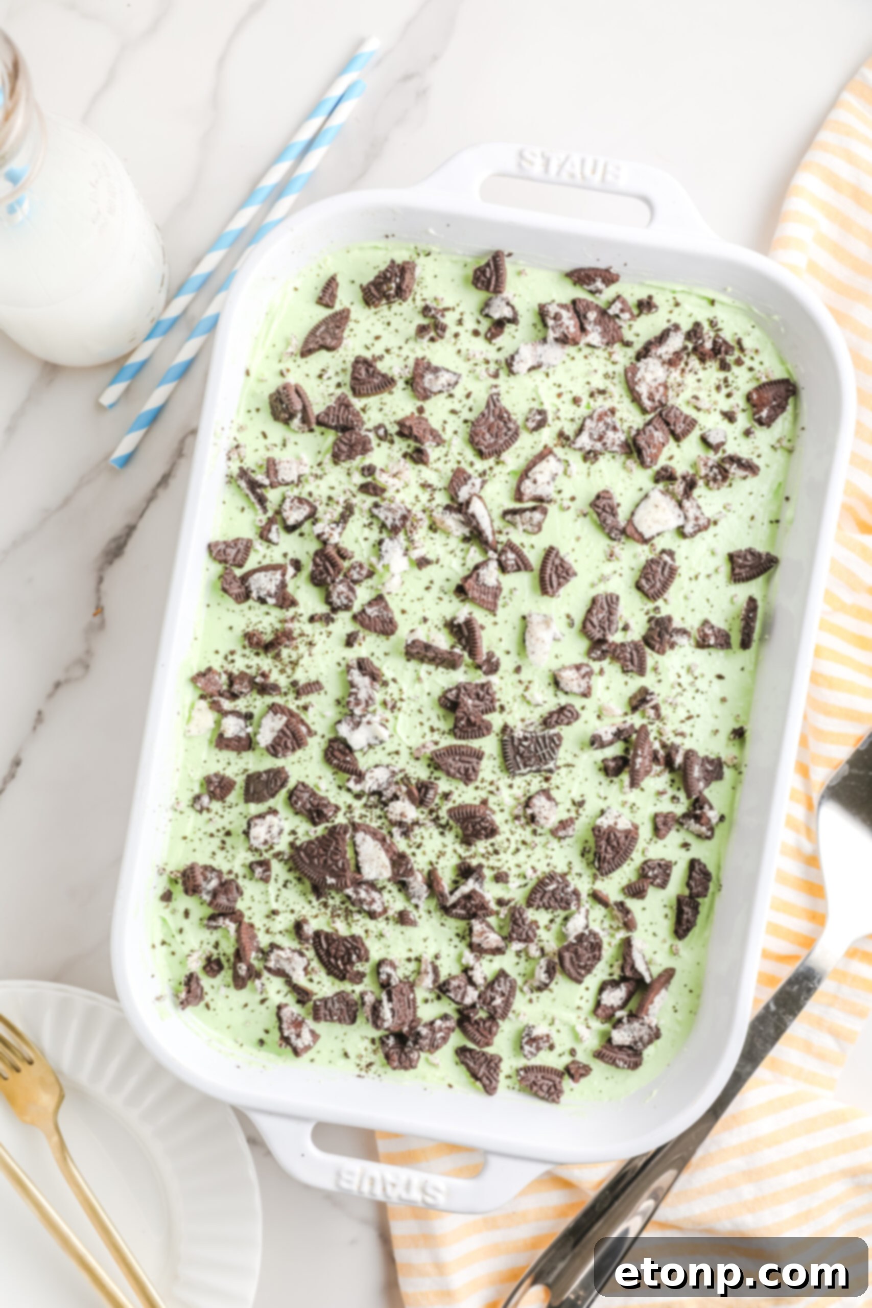 An inviting overhead view of the full Shamrock Lasagna in a classic white baking dish, generously topped with a sprinkle of crushed Oreos, showcasing its appealing texture.