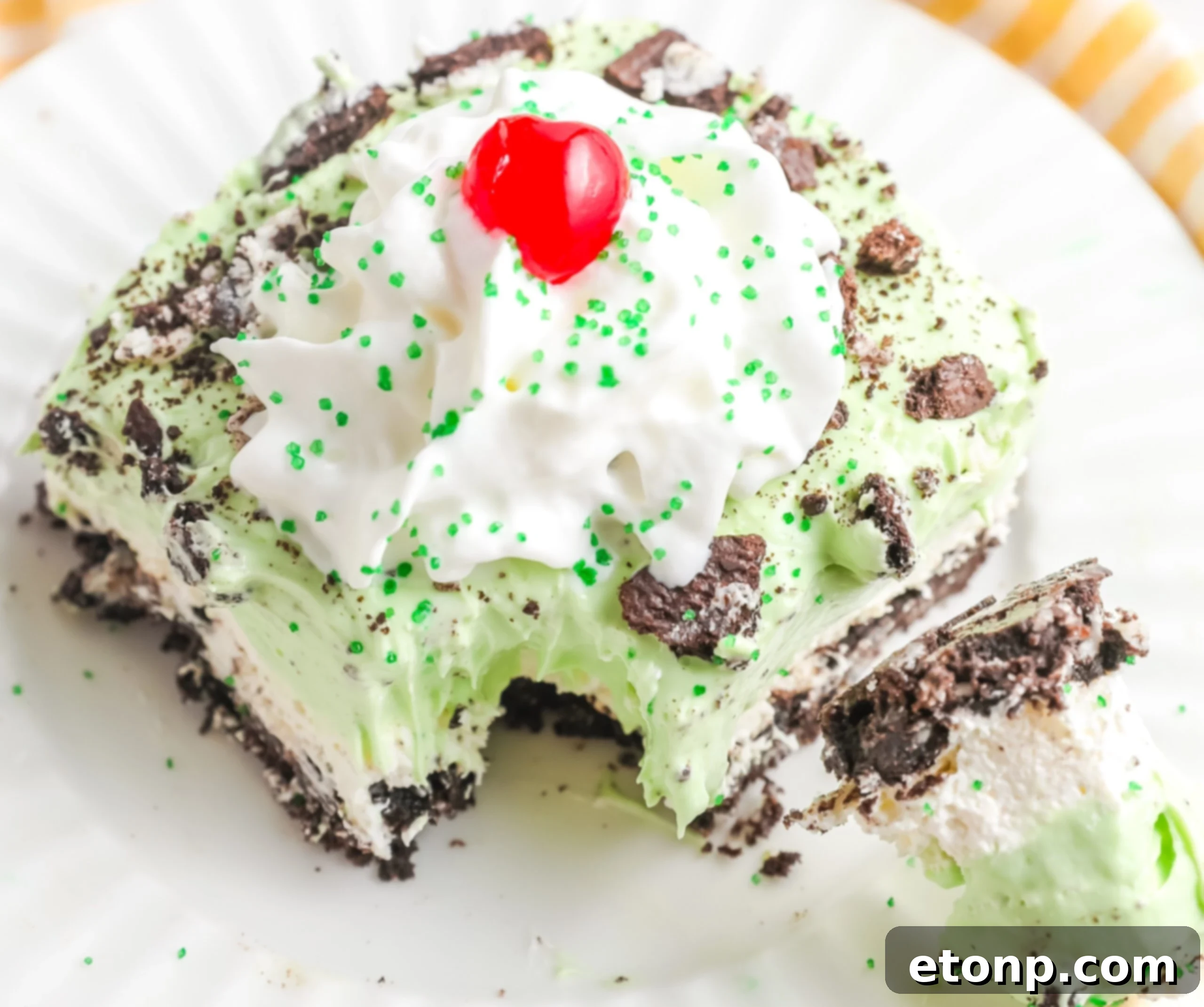 A close-up side angle of a single slice of Shamrock Lasagna on a white plate, with a bite playfully removed on a fork, highlighting its inviting layers.