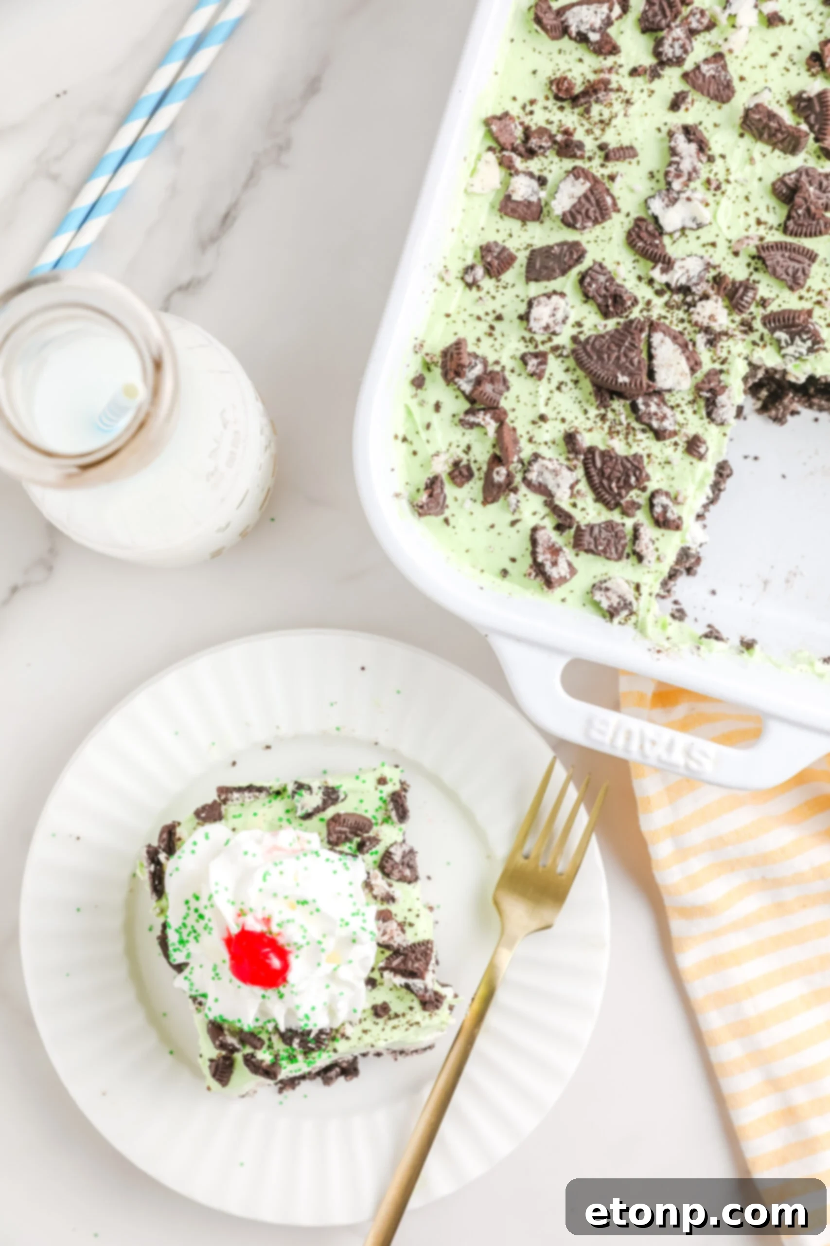 An inviting overhead shot of the Shamrock Lasagna in its baking dish, with a single perfect slice carefully removed onto a white plate, accompanied by a gold fork, ready to be savored.