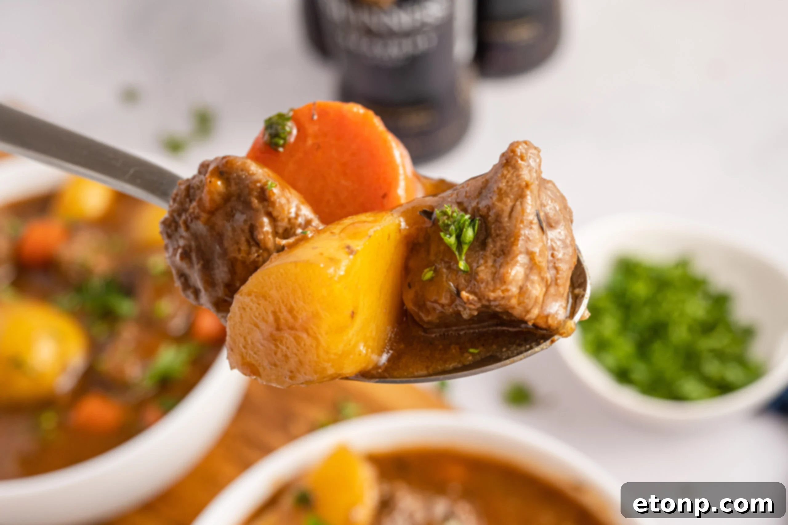 Two bowls of Irish stew with a spoon lifting up a bite