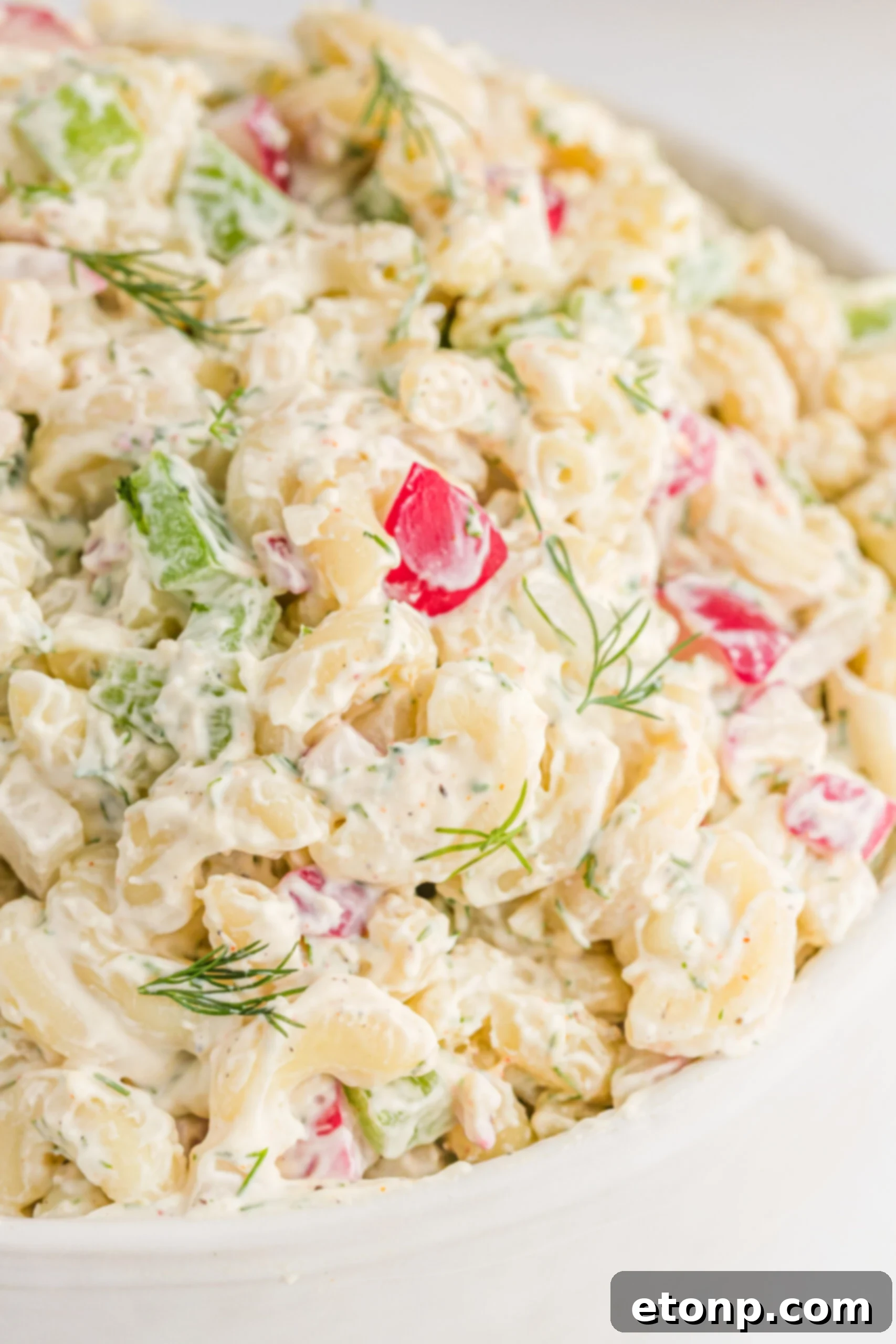 Creamy Dill Macaroni Salad 2 Close up view of Macaroni Dill Pasta Salad in a white serving bowl, showcasing its creamy texture and fresh dill.