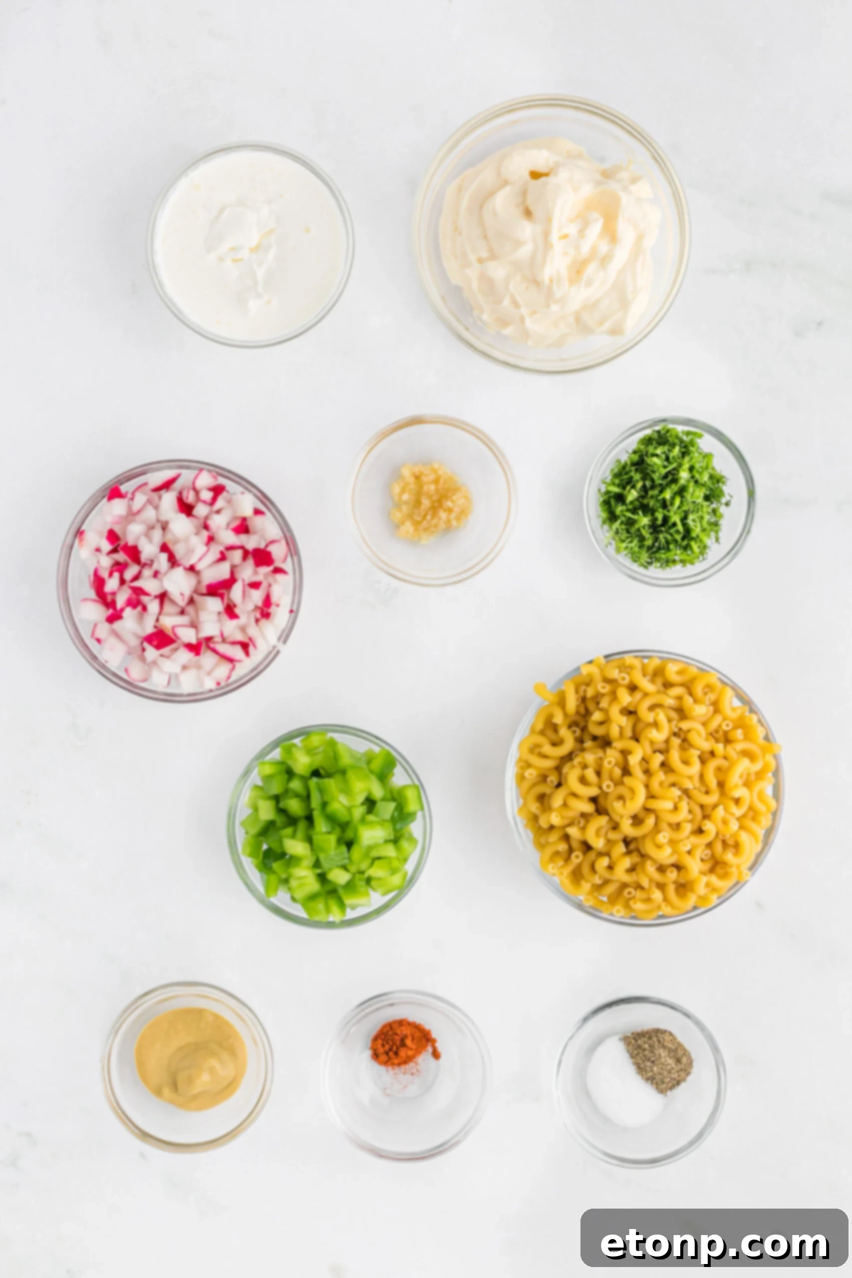 Creamy Dill Macaroni Salad 7 Overhead view of all fresh ingredients laid out on a table, including macaroni, dill, radish, green pepper, and dressing components.