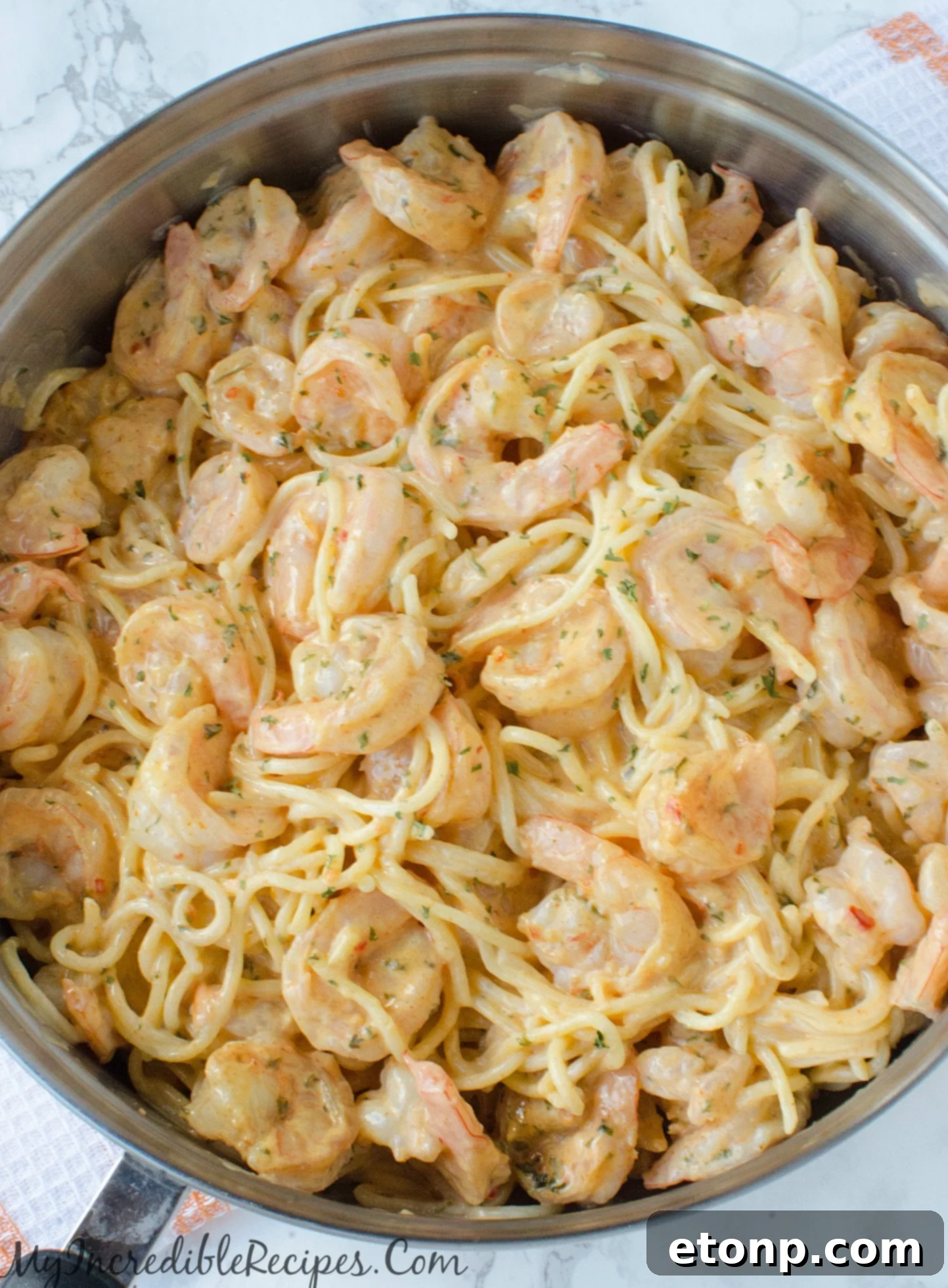 A freshly prepared plate of Bang Bang Shrimp Pasta, garnished with parsley.