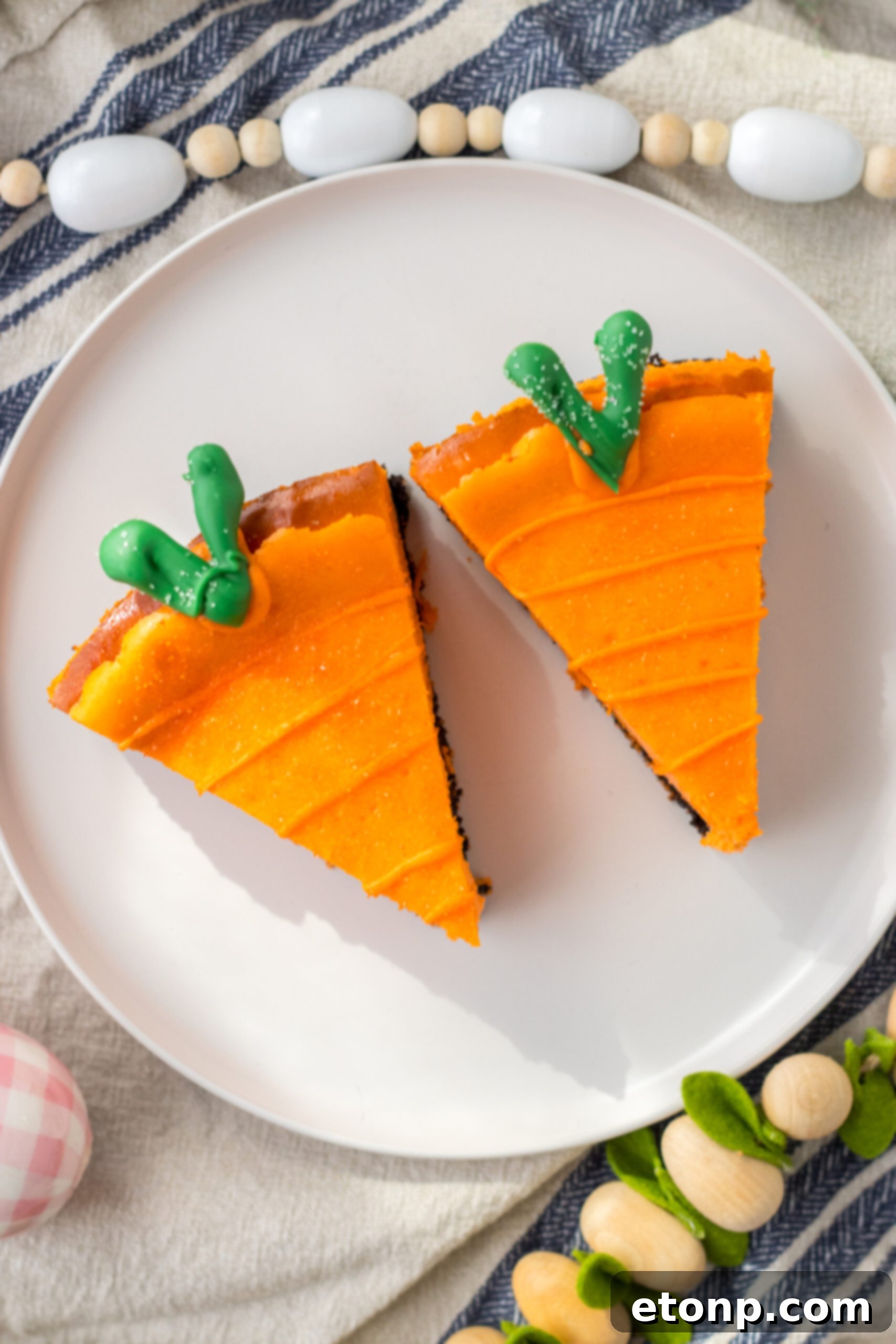 Carrot Cake Cheesecake 13 Overhead view of two Cheesecake Carrots on a white plate.