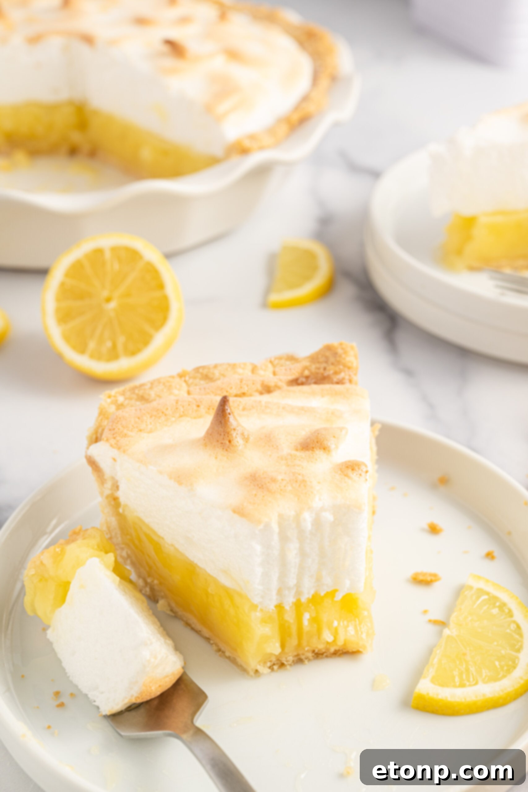 Another close-up of a bite into the fresh lemon meringue pie, emphasizing its delightful texture.