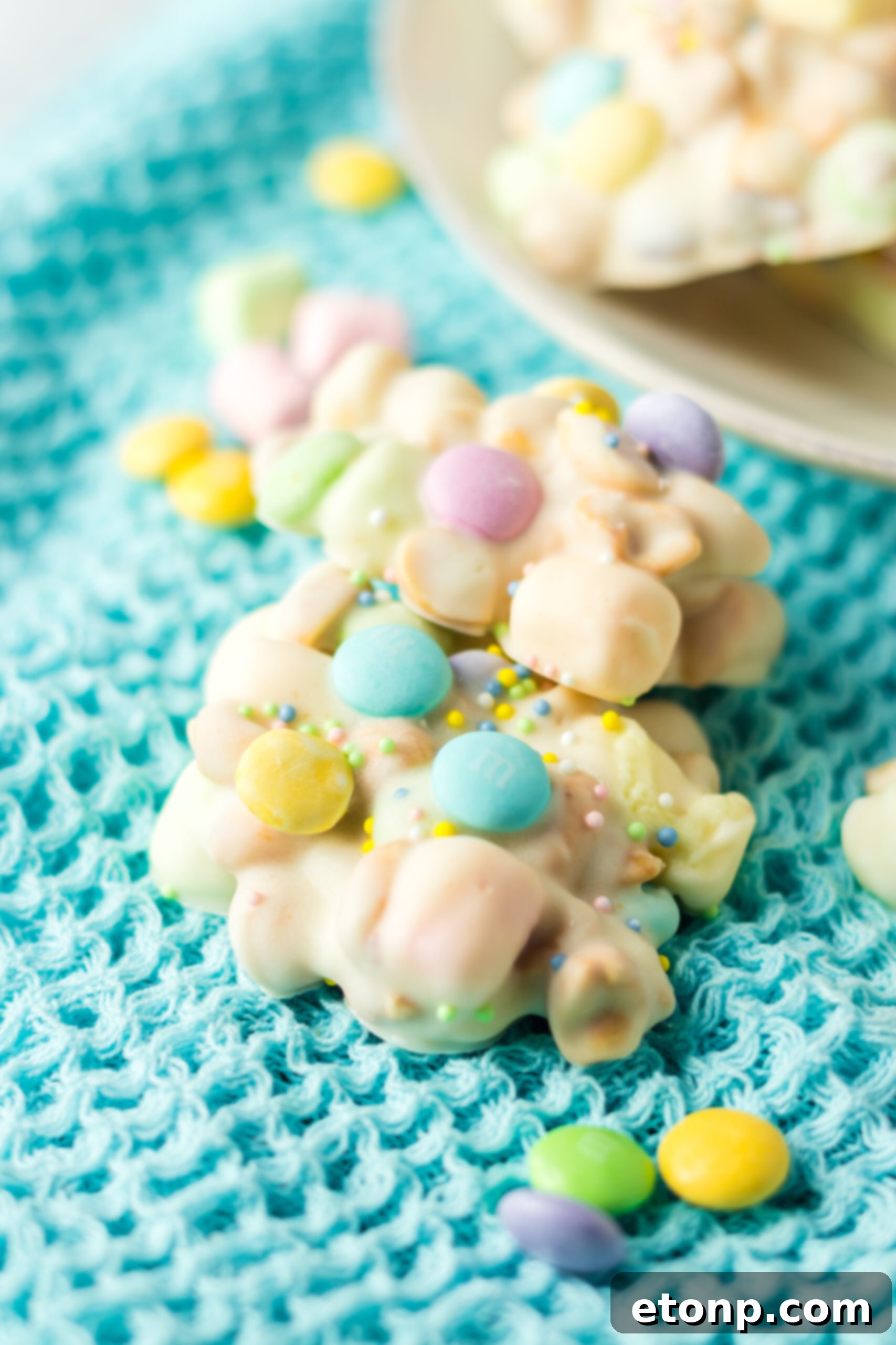 Two pieces of slow cooker Easter candy on a teal linen. 