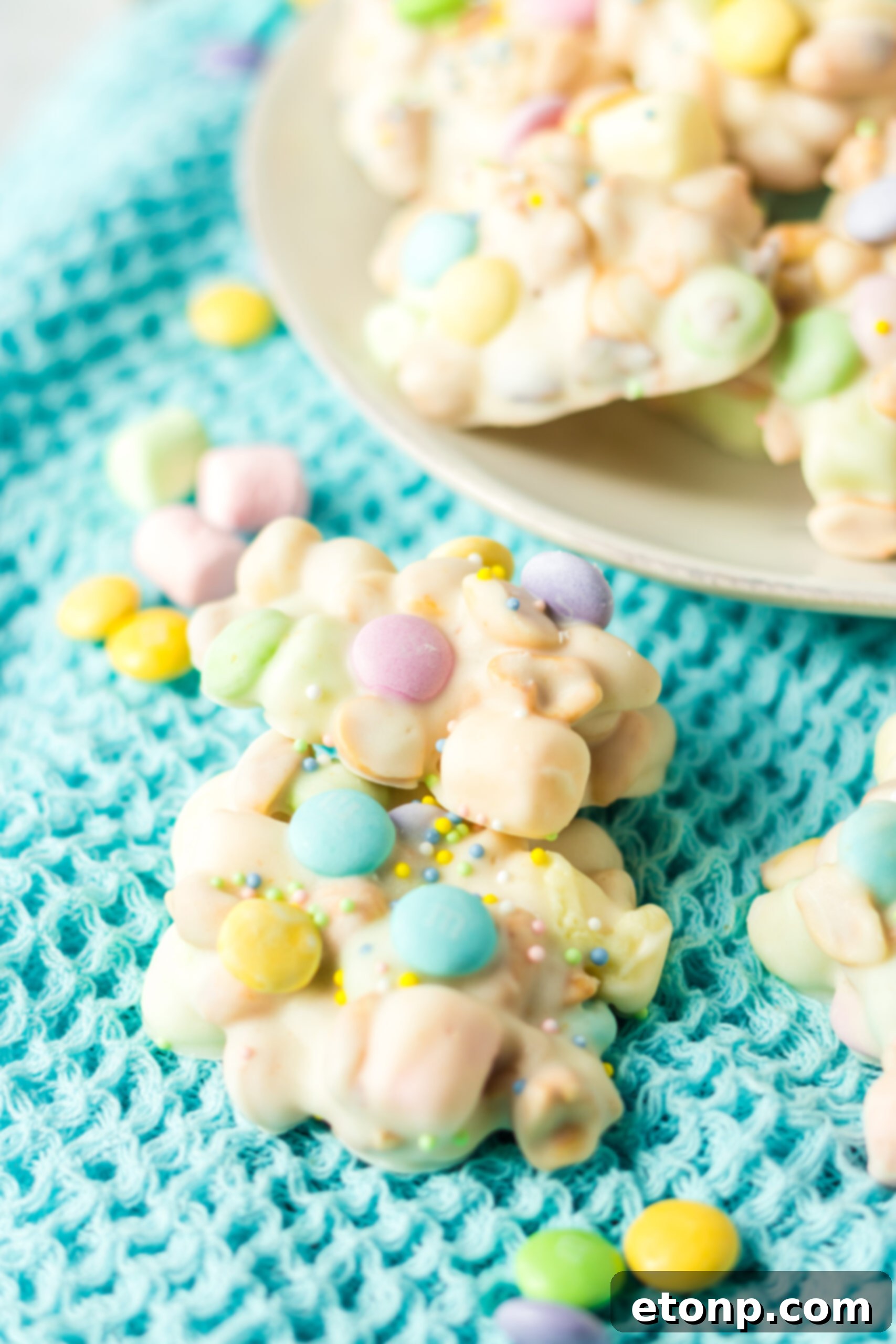Two pieces of slow cooker Easter candy stacked on a teal linen. 