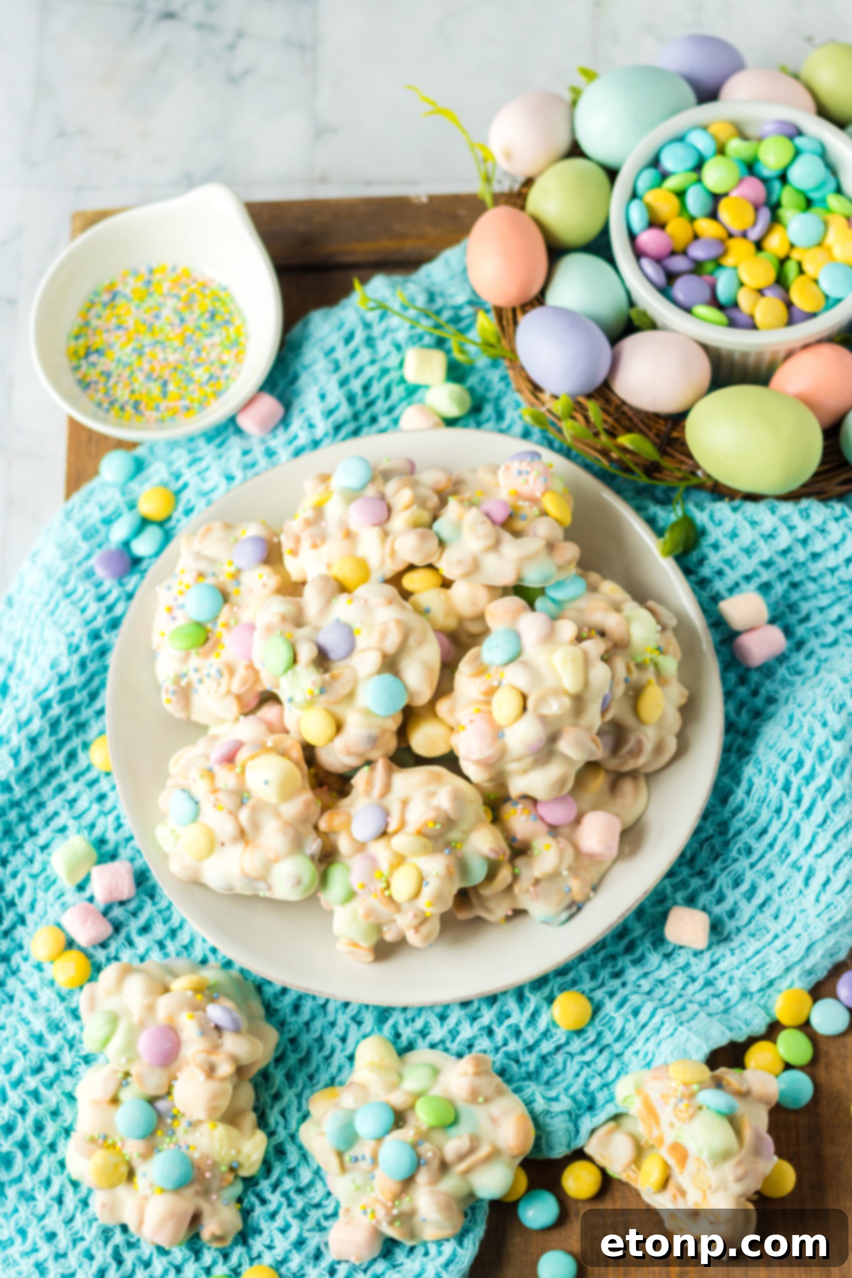 Slow Cooker Easter Candy stacked on a white plate on top of a teal linen. 