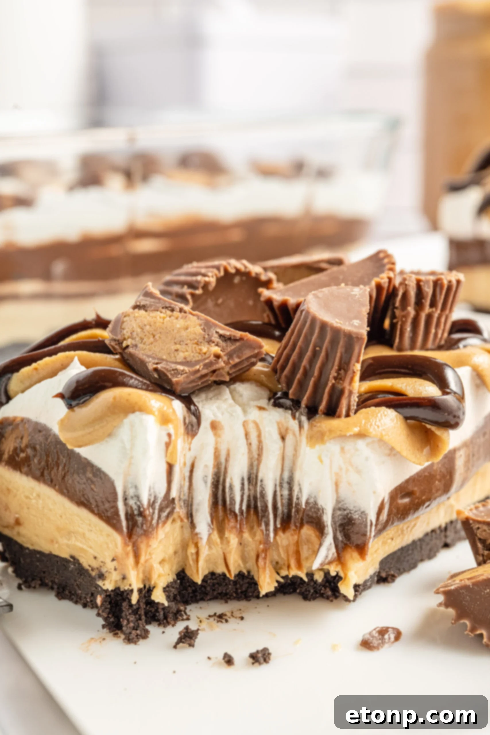 Close up bite shot of the chocolate peanut butter lasagna on a white plate.