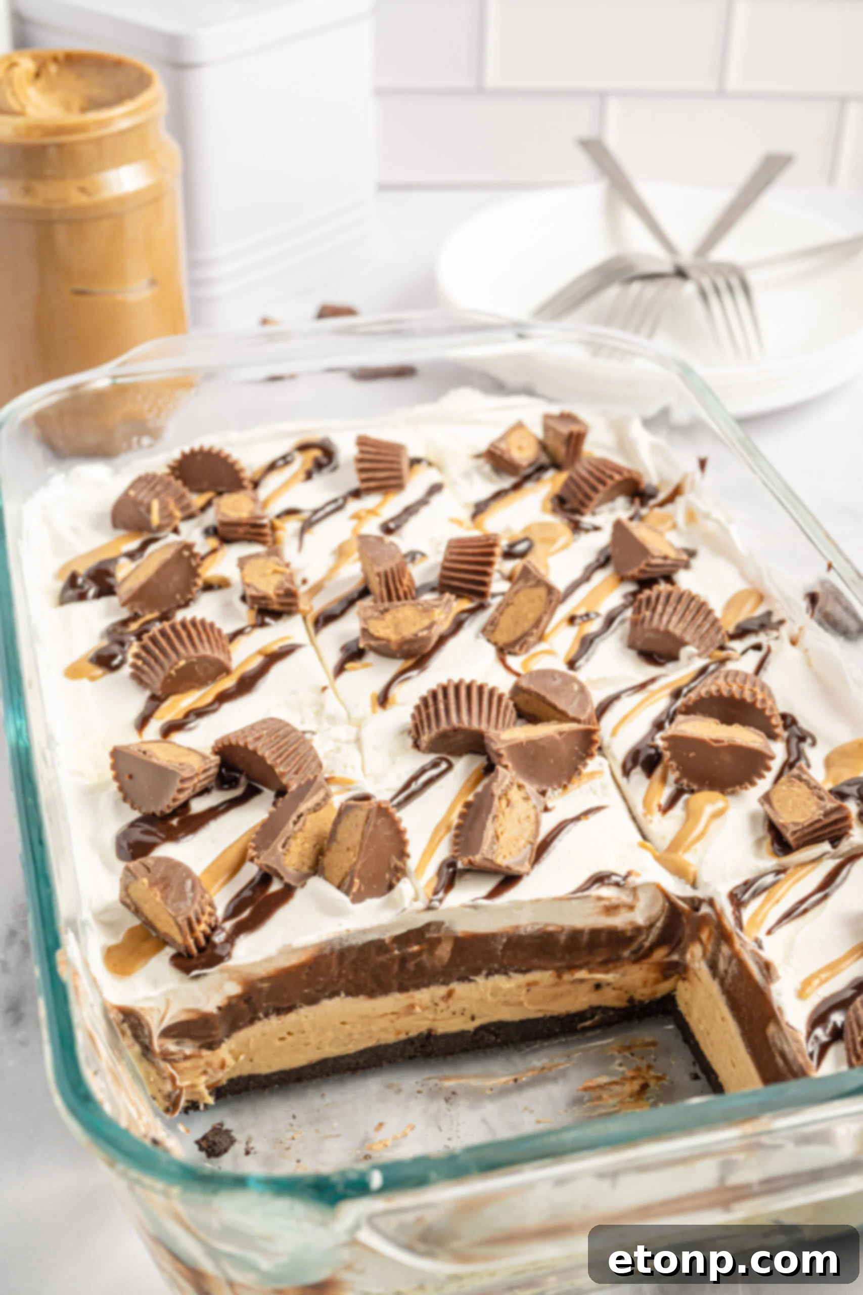 chocolate peanut butter lasagna in a glass baking pan with two slices removed.