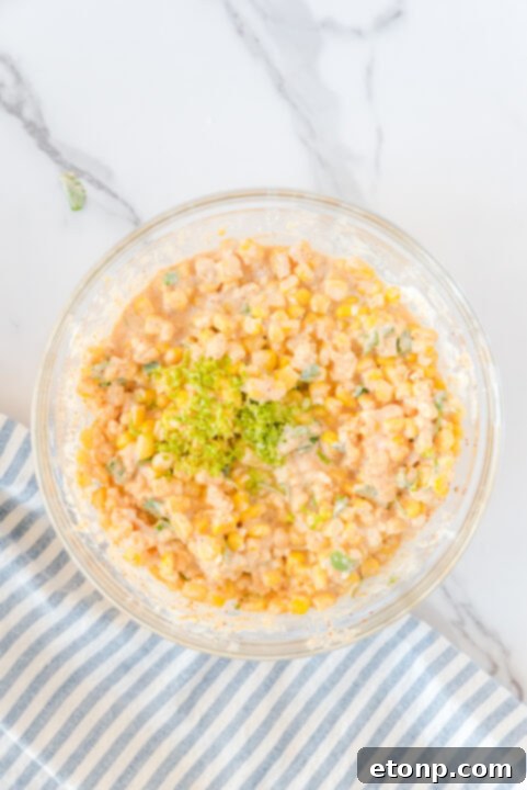 Spices like chili powder, smoked paprika, and cumin being added to the corn mixture.