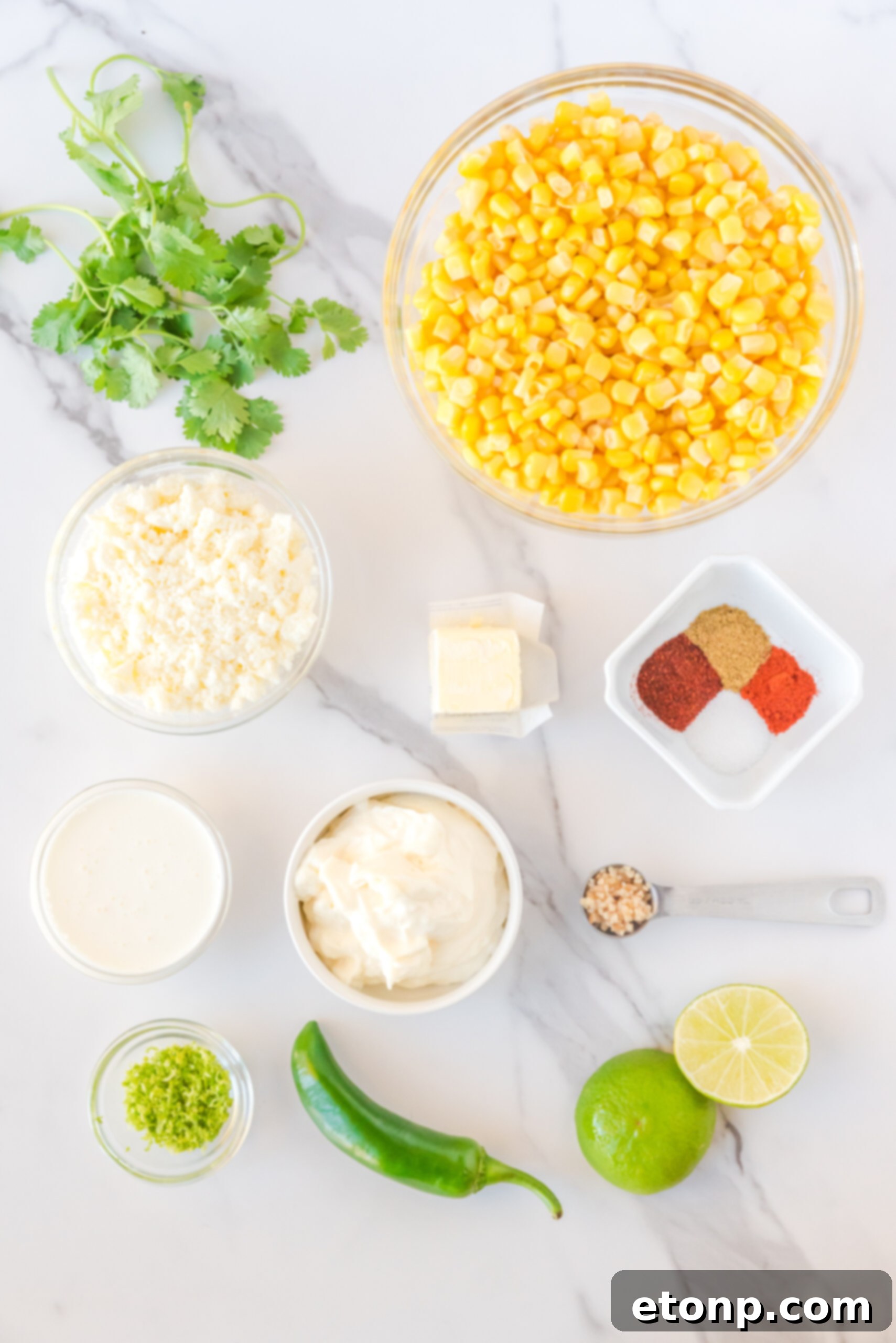All the fresh ingredients for making Mexican Street Corn Salad laid out neatly on a surface.