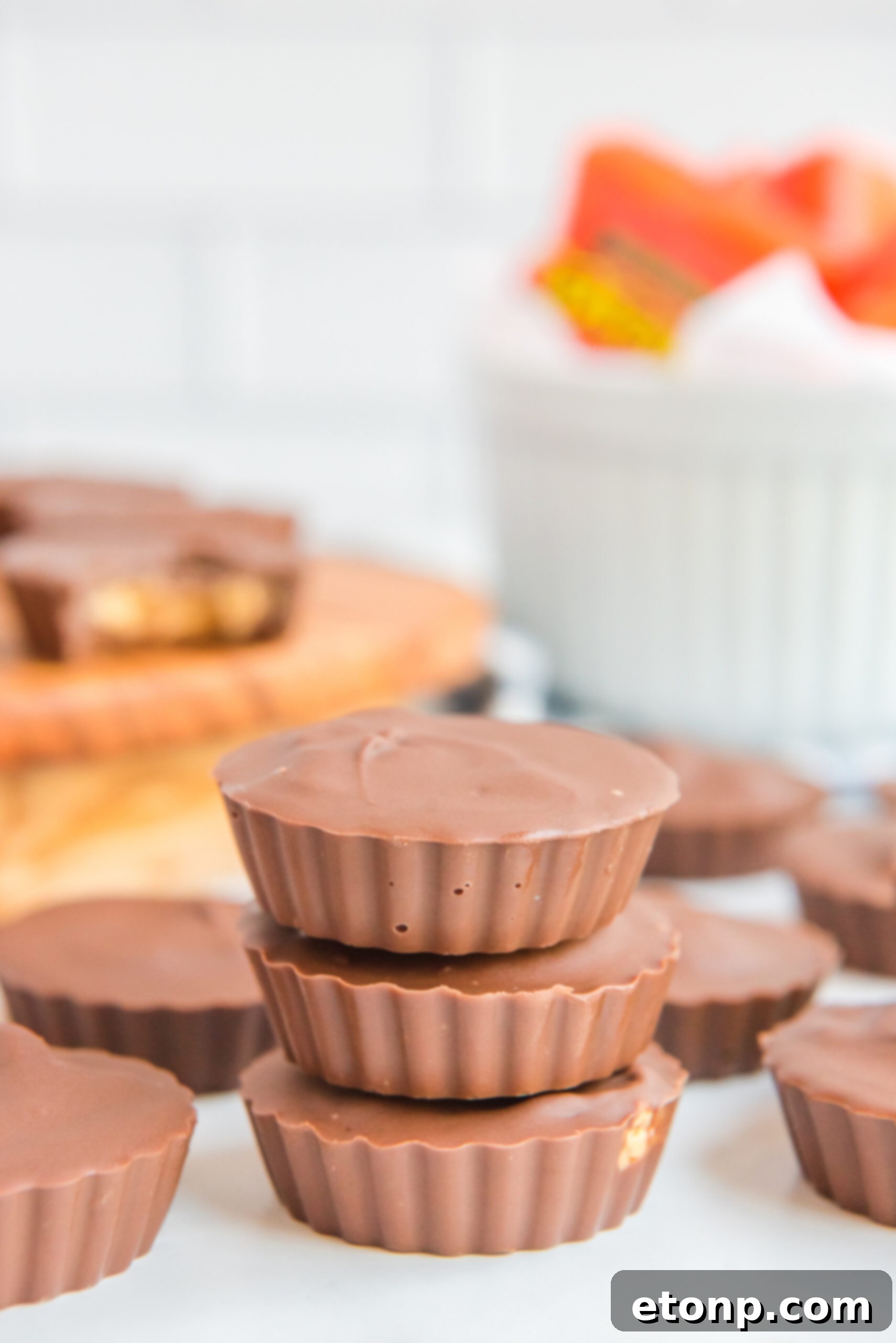 Homemade Peanut Butter Chocolate Cups 4 Three perfectly molded homemade Reese's Peanut Butter Cups stacked vertically, displaying their uniform shape and appealing texture.