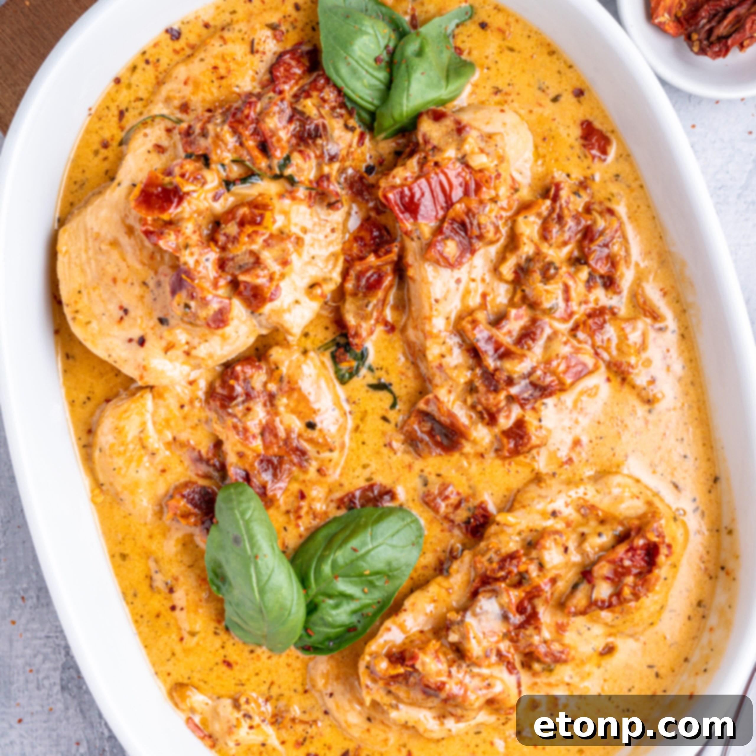 Heart-Winning Chicken 2 Marry Me Chicken in a white baking dish topped with fresh basil, ready to serve.