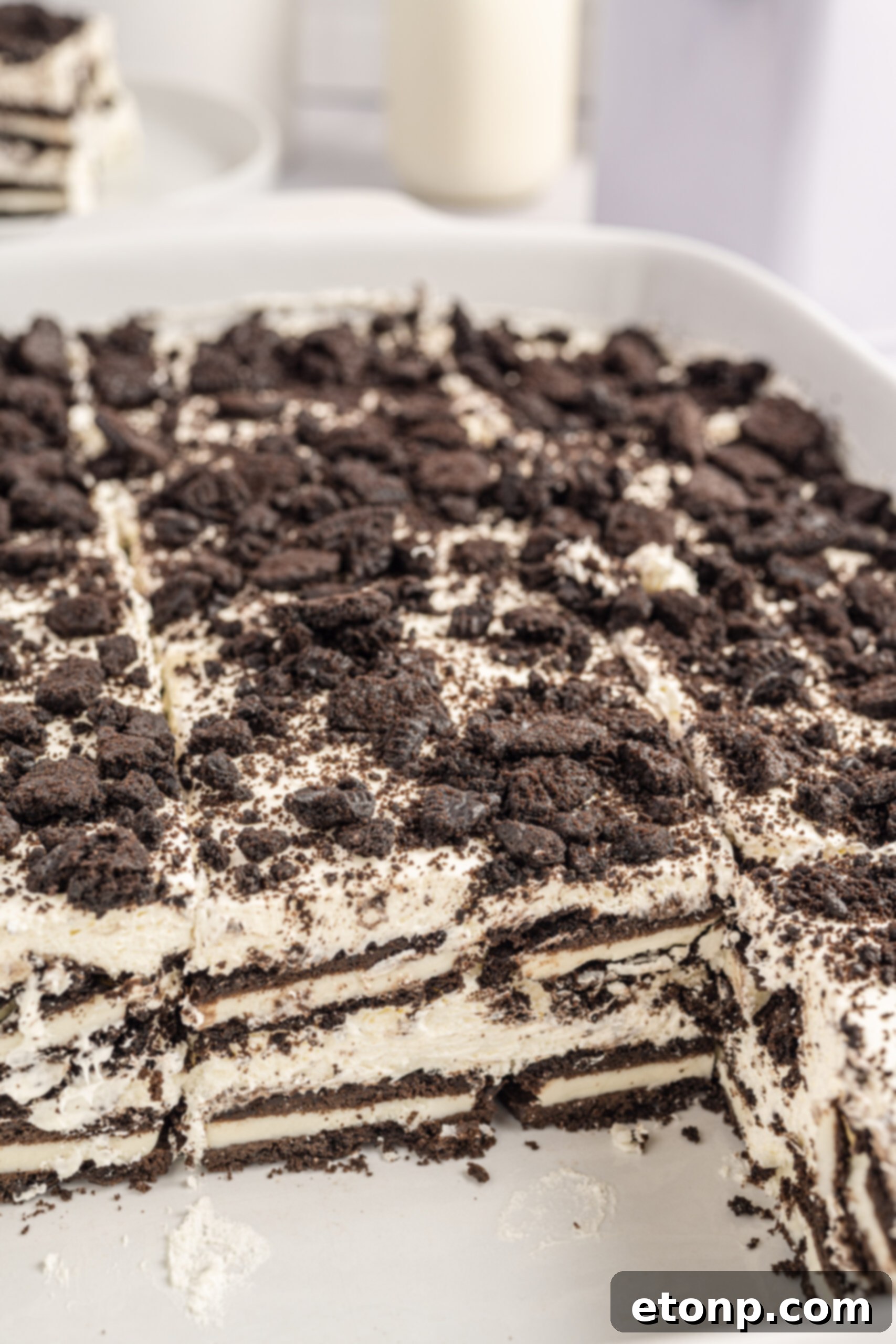 Oreo Cream Dream 16 Close up view of Oreo Icebox Cake with two slices removed in a white baking dish.
