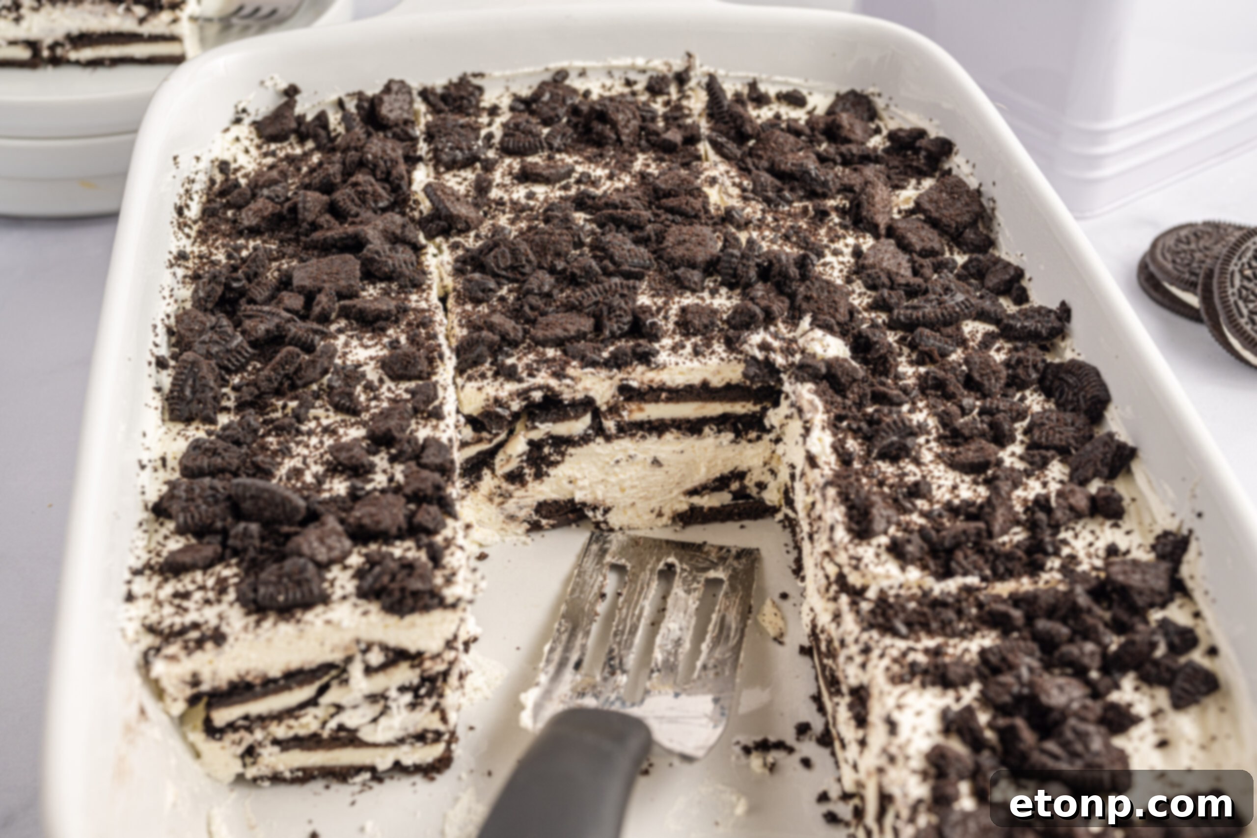 Oreo Cream Dream 3 Front view of a slice of Oreo Icebox Cake on a silver cake server.