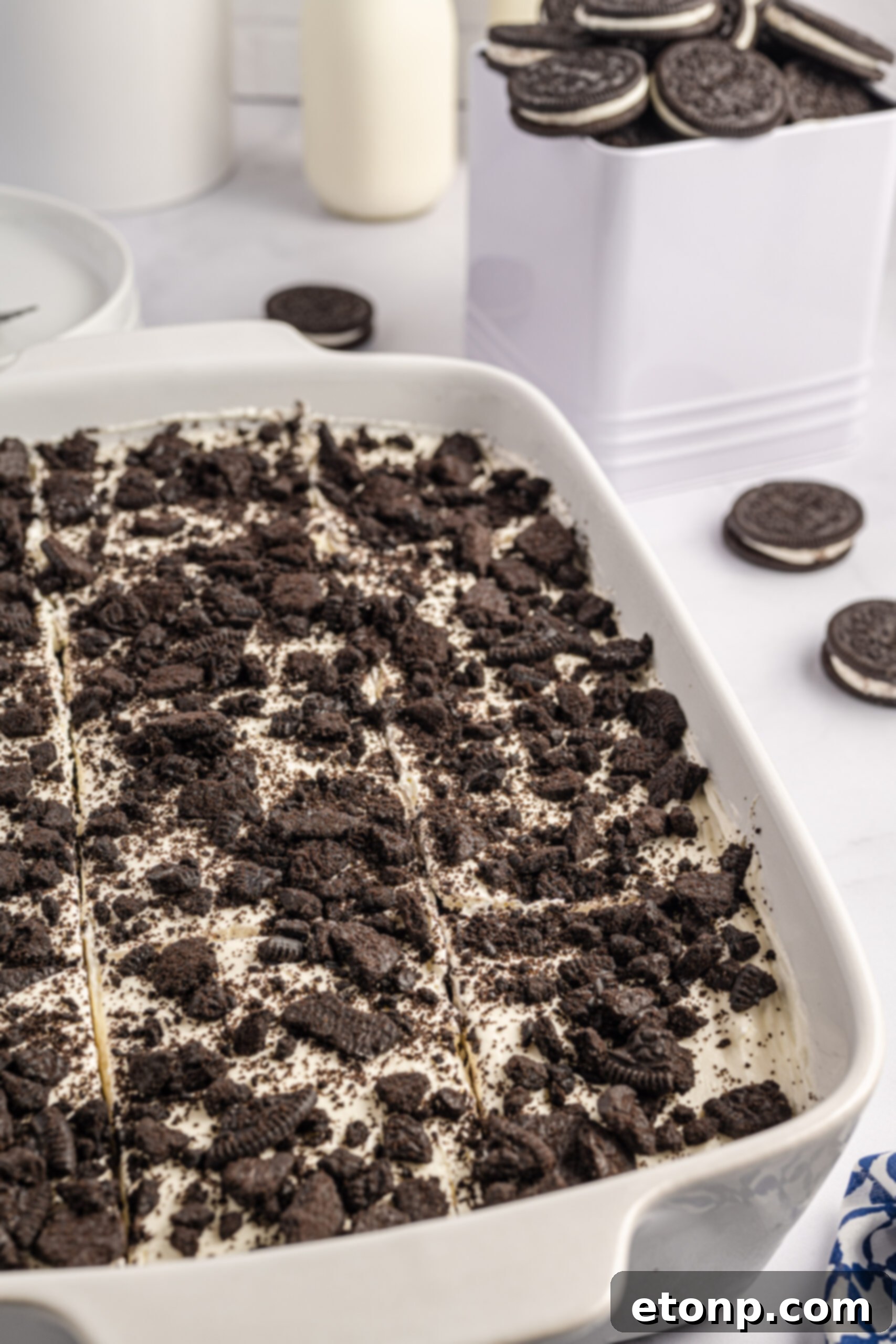 Oreo Cream Dream 7 Overhead view of Oreo Icebox Cake, cut into slices, in a white baking dish.