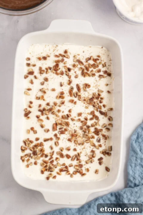 Adding whipped topping to the cream cheese mixture.