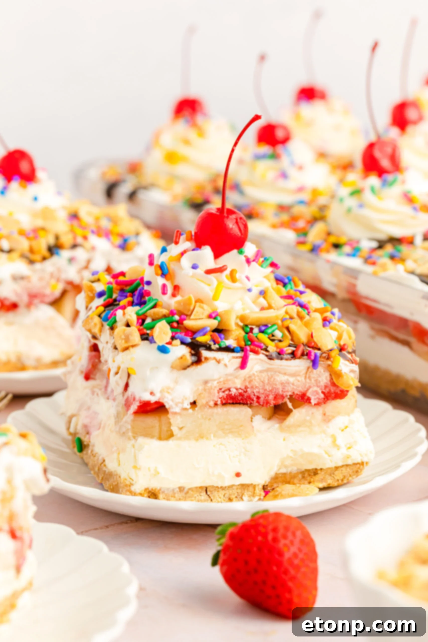 No-Bake Banana Split Bliss 2 Delicious slice of No Bake Banana Split Cake on a white plate, showcasing its vibrant layers.