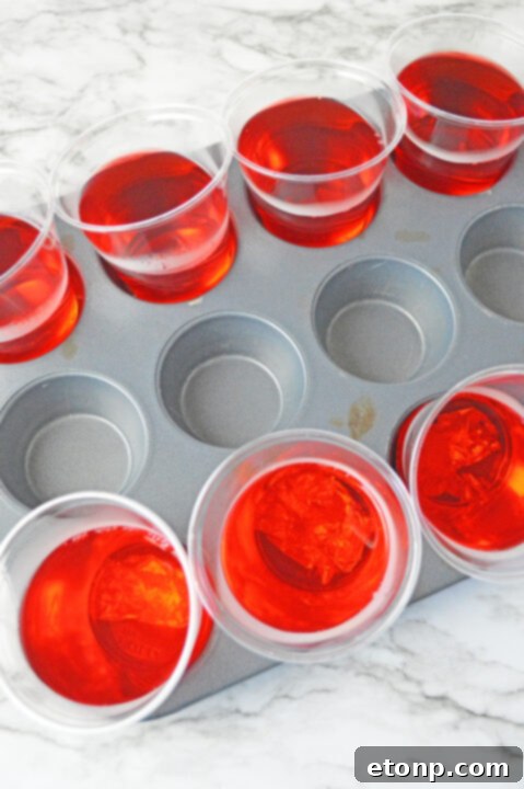 Strawberry Dream Parfaits 10 Cool Whip being whisked into cooled pink jello mixture.