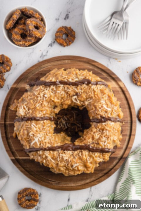 A freshly baked Samoa bundt cake, perfectly golden brown, cooling on a wire rack after being carefully inverted from the pan.
