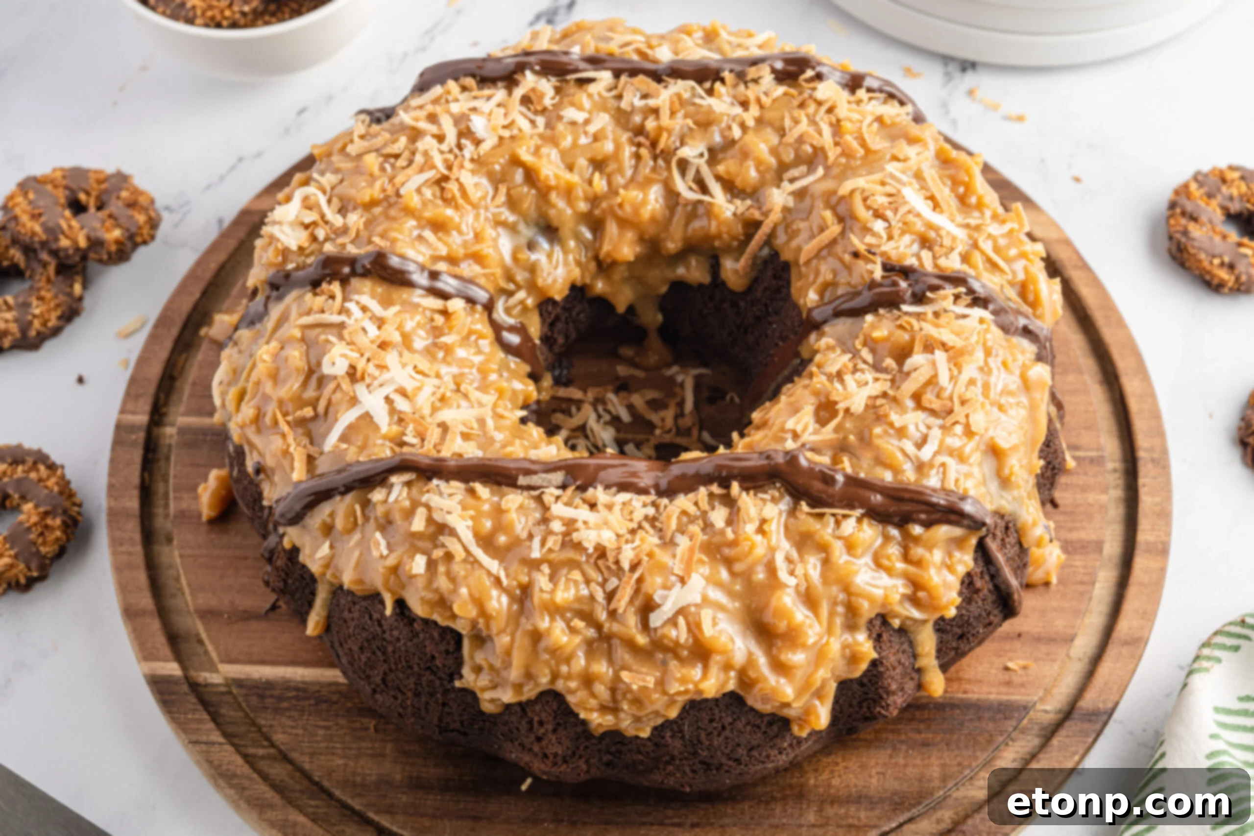 An inviting overhead view of the full Samoa Cake on a wooden cutting board, with several slices already enjoyed, highlighting its undeniable popularity and deliciousness.