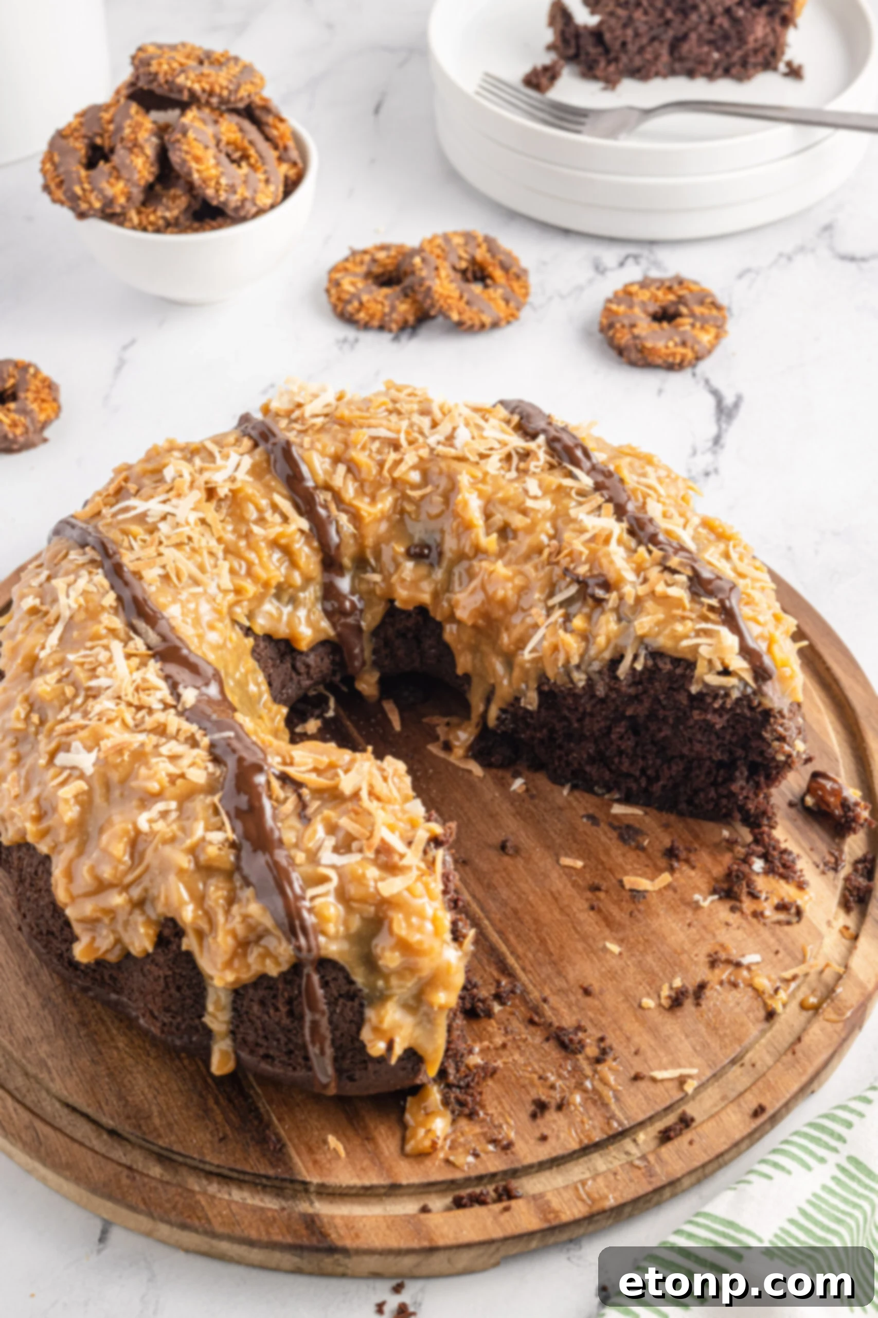 Overhead view of a Samoa Cake on a wooden cutting board, with multiple slices already served, indicating a popular dessert, potentially a Double Chocolate Samoa Cake variation.