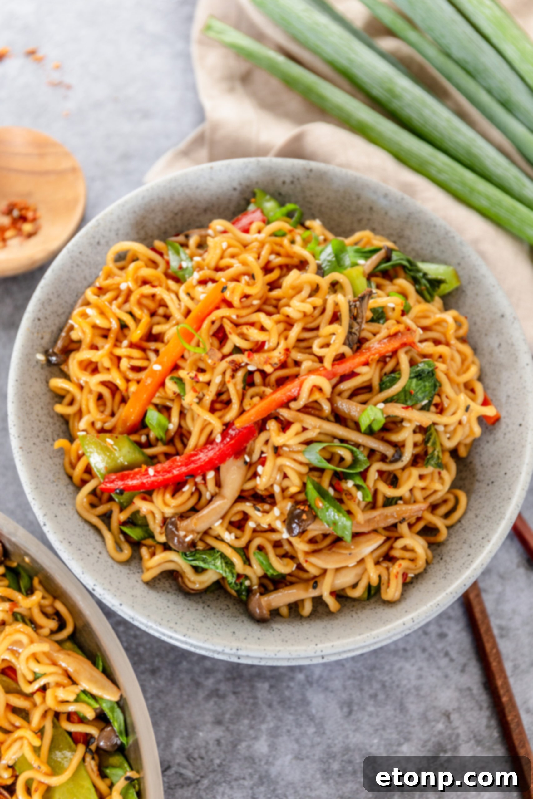 Another perspective of a speckled white bowl filled with delicious Ramen Stir Fry, highlighting the diverse vegetables.