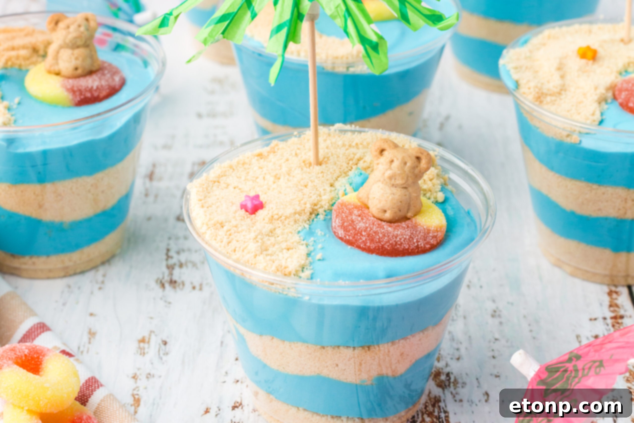 Front view of multiple Beach Cheesecake Pudding Cups arranged neatly, showing off their colorful toppings and beach decorations.