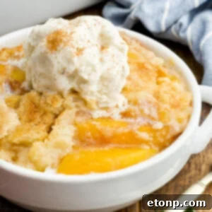 A serving of Peach Dump Cake in a white bowl.