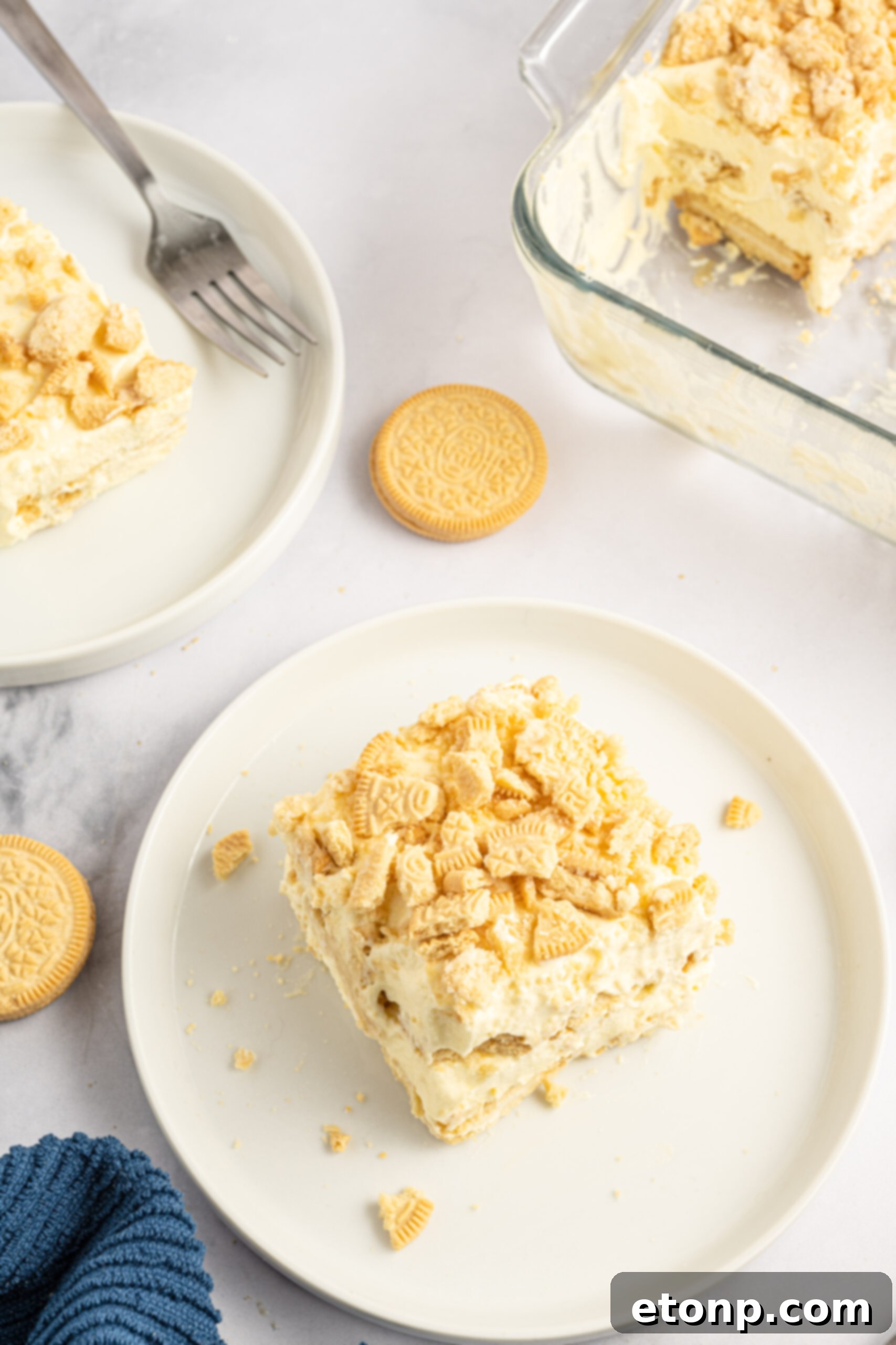 Overhead view of a beautiful slice of Golden Oreo Icebox Cake on a white plate, showing the clean layers.