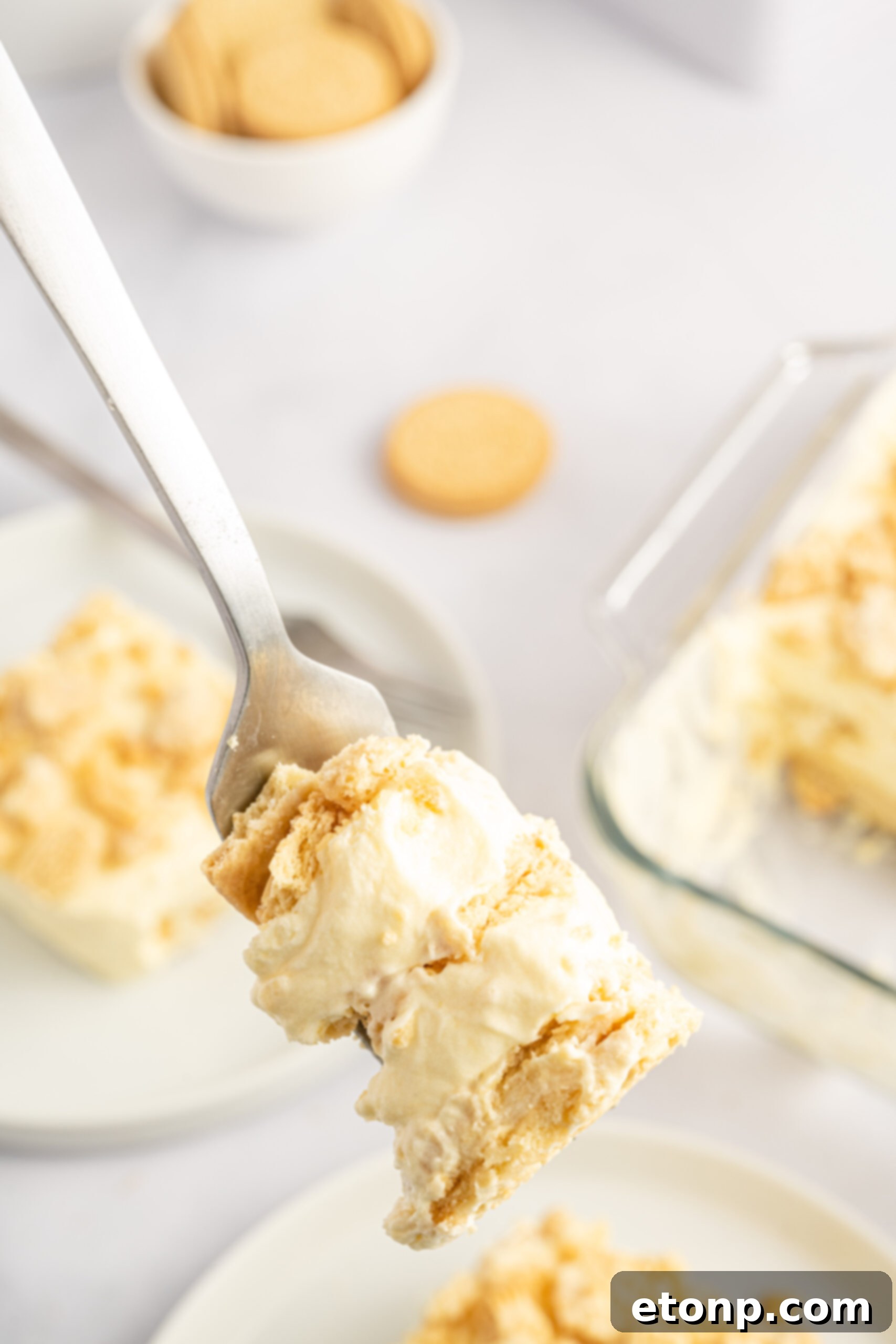 Close up view of a perfect bite of Golden Oreo Icebox Cake on a silver fork, showing crisp layers.