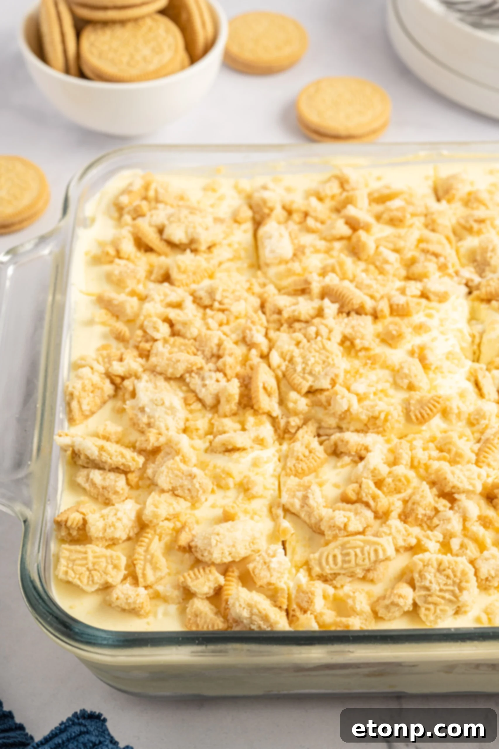 Close up view of Golden Oreo Icebox Cake in a clear baking dish, highlighting the texture and layers.