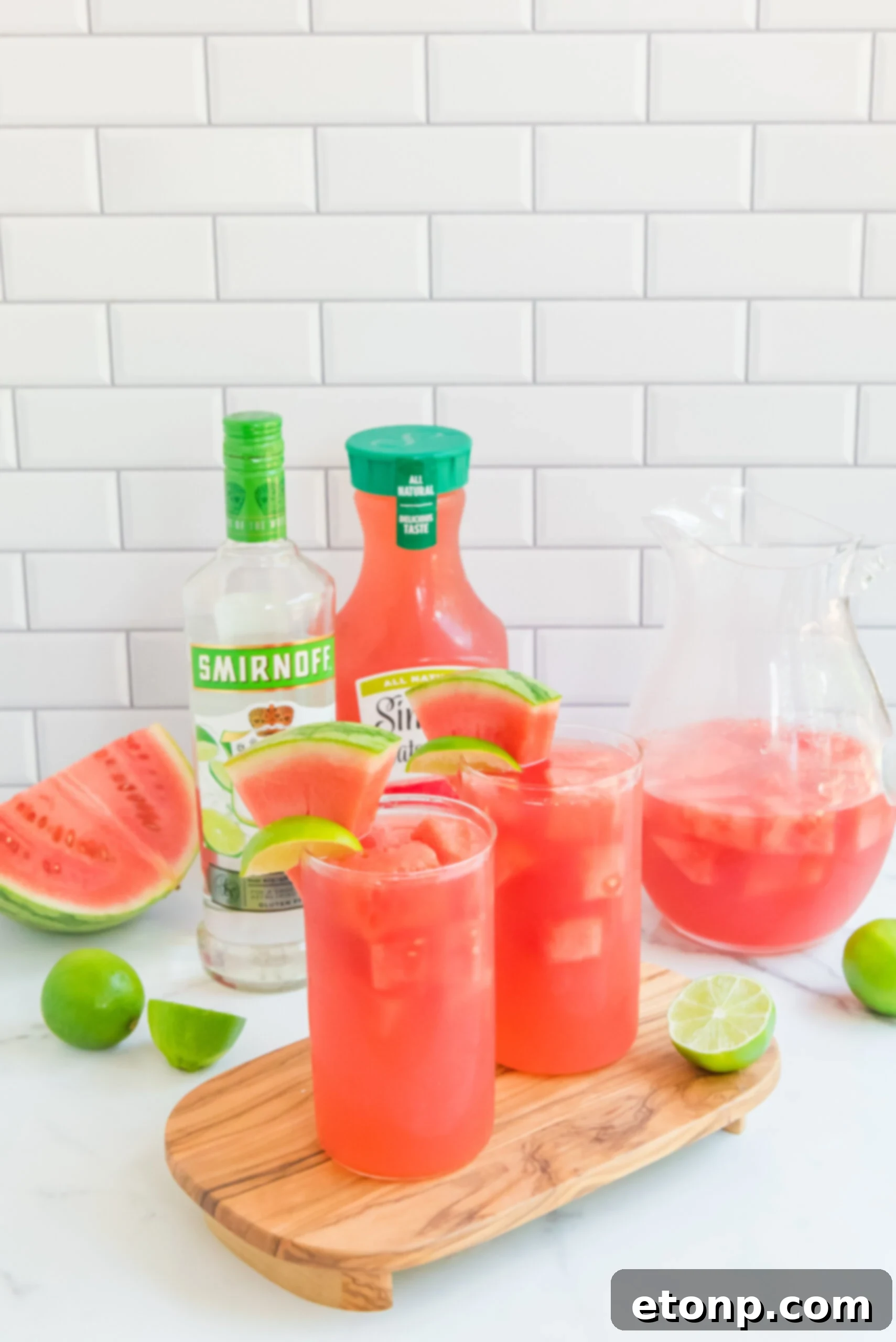 Front view of Watermelon Cocktail in two clear glasses garnished with lime and watermelon slices.
