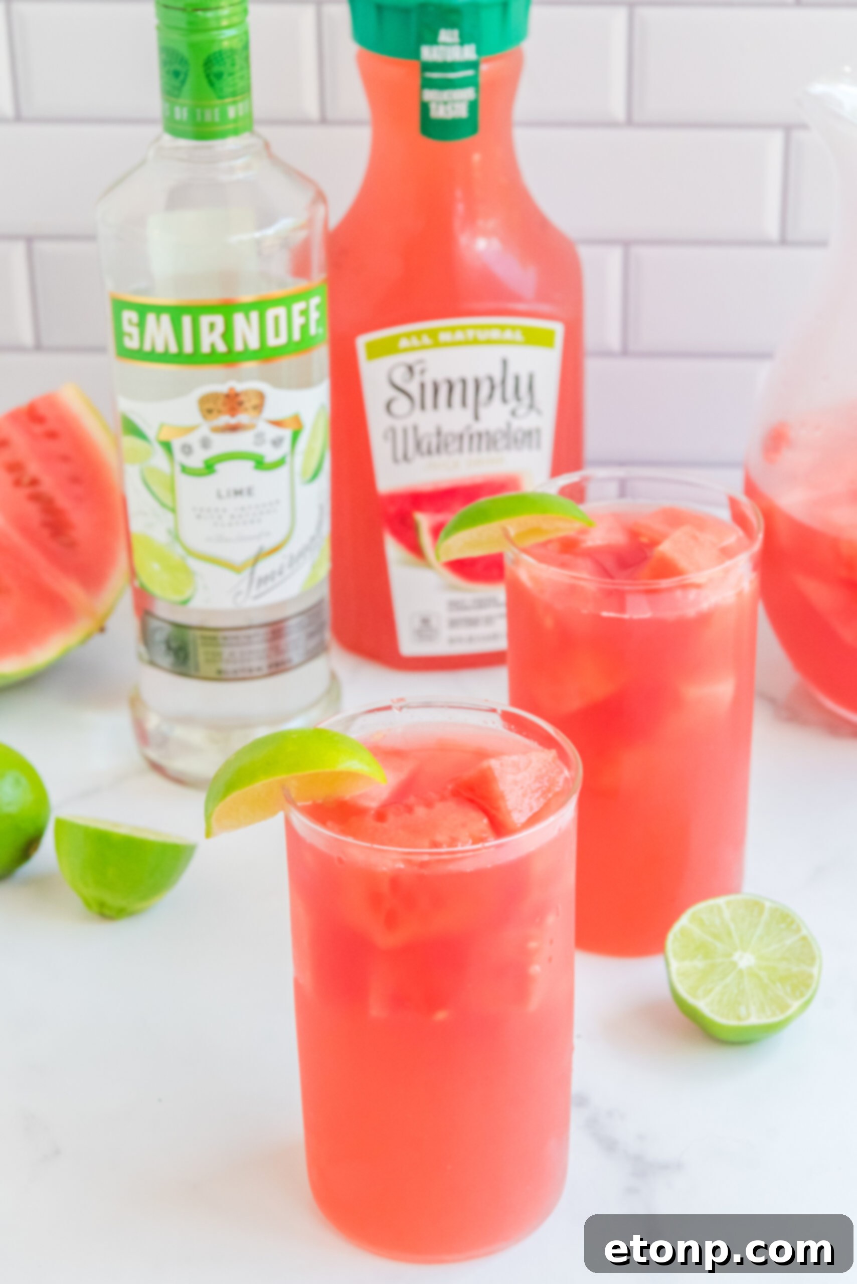 Front view of Watermelon Cocktail in two clear glasses garnished with a lime wedge.