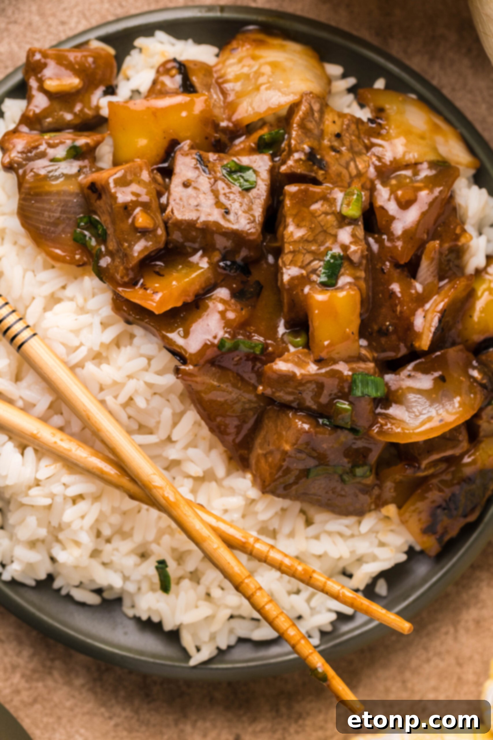 Overhead view of Teriyaki Steak Bites in a black dish served with white rice.