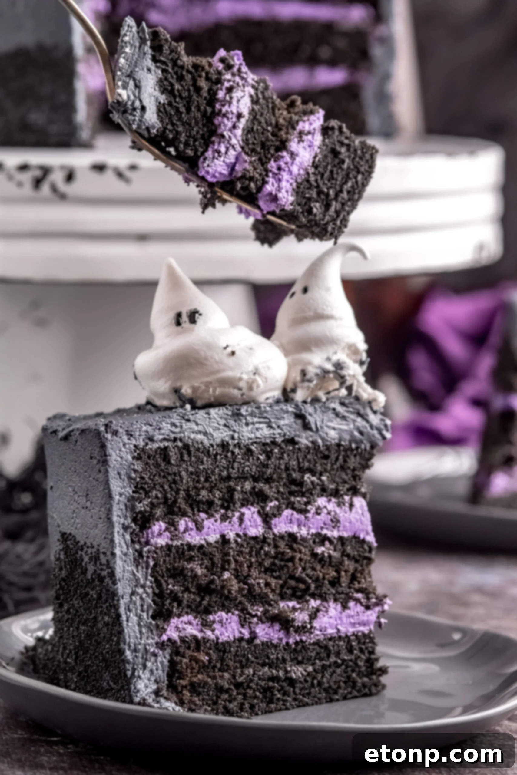 Halloween cake slice on black plate showing the purple frosting layers
