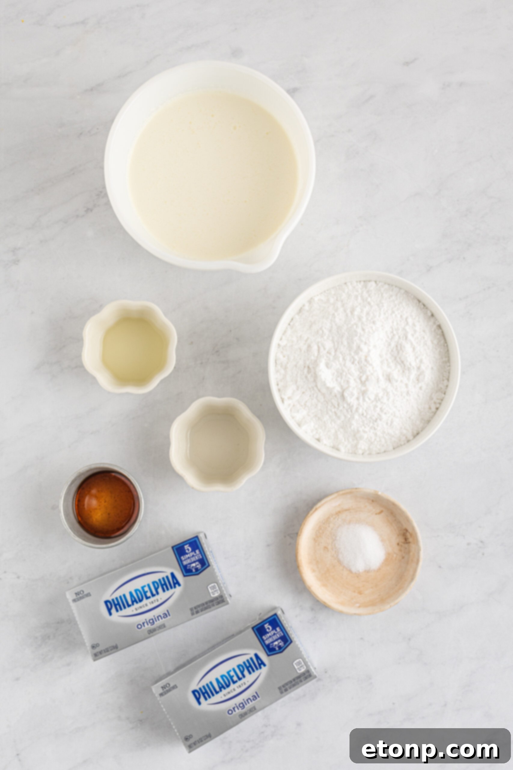 A curated display of all the essential ingredients needed to create the rich and tangy cream cheese layer for the icebox cake.