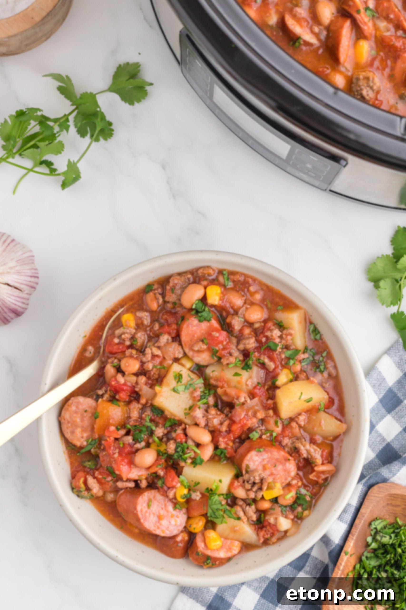 Hearty Lone Star Slow Cooker Stew 12 Overhead view of a serving of Slow Cooker Texas Cowboy Stew in a white bowl, ready to be enjoyed.