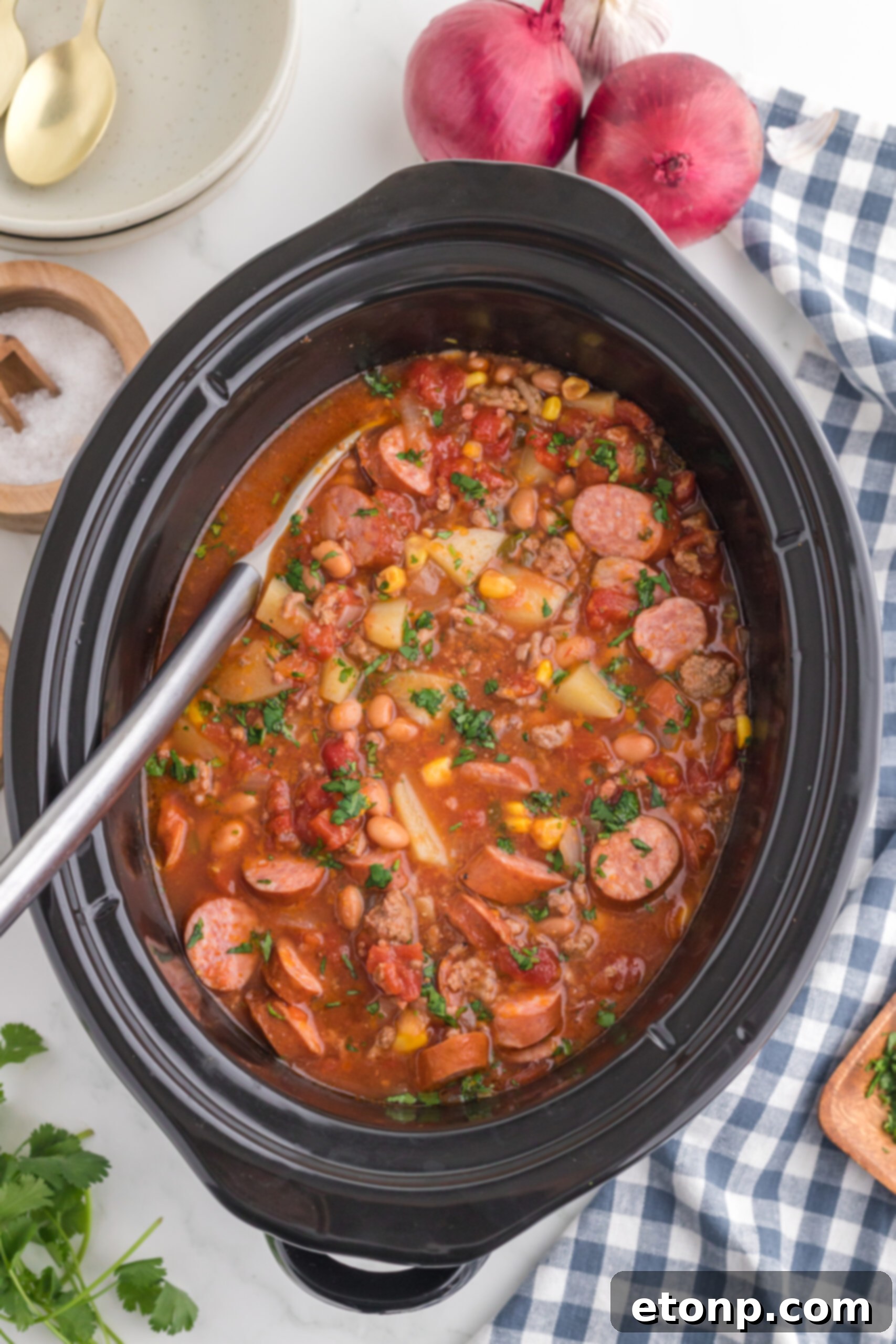 Hearty Lone Star Slow Cooker Stew 15 Slow Cooker Texas Cowboy Stew in a crock pot with a metal spoon inside, ready to serve.