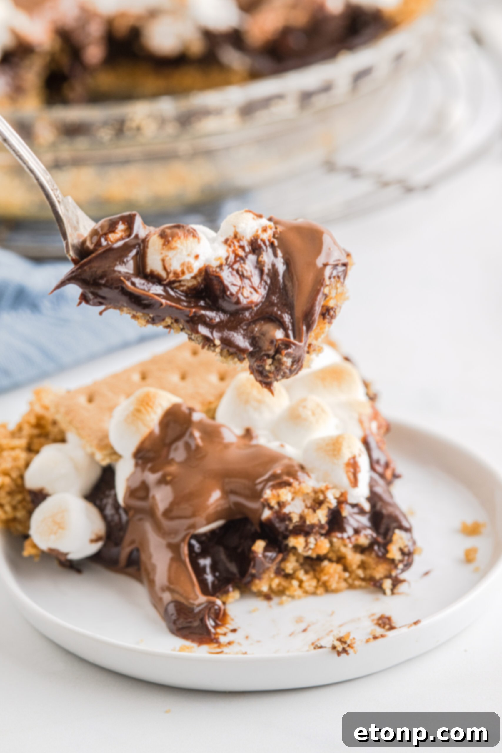 A silver fork removing a bite of S'mores Pie.