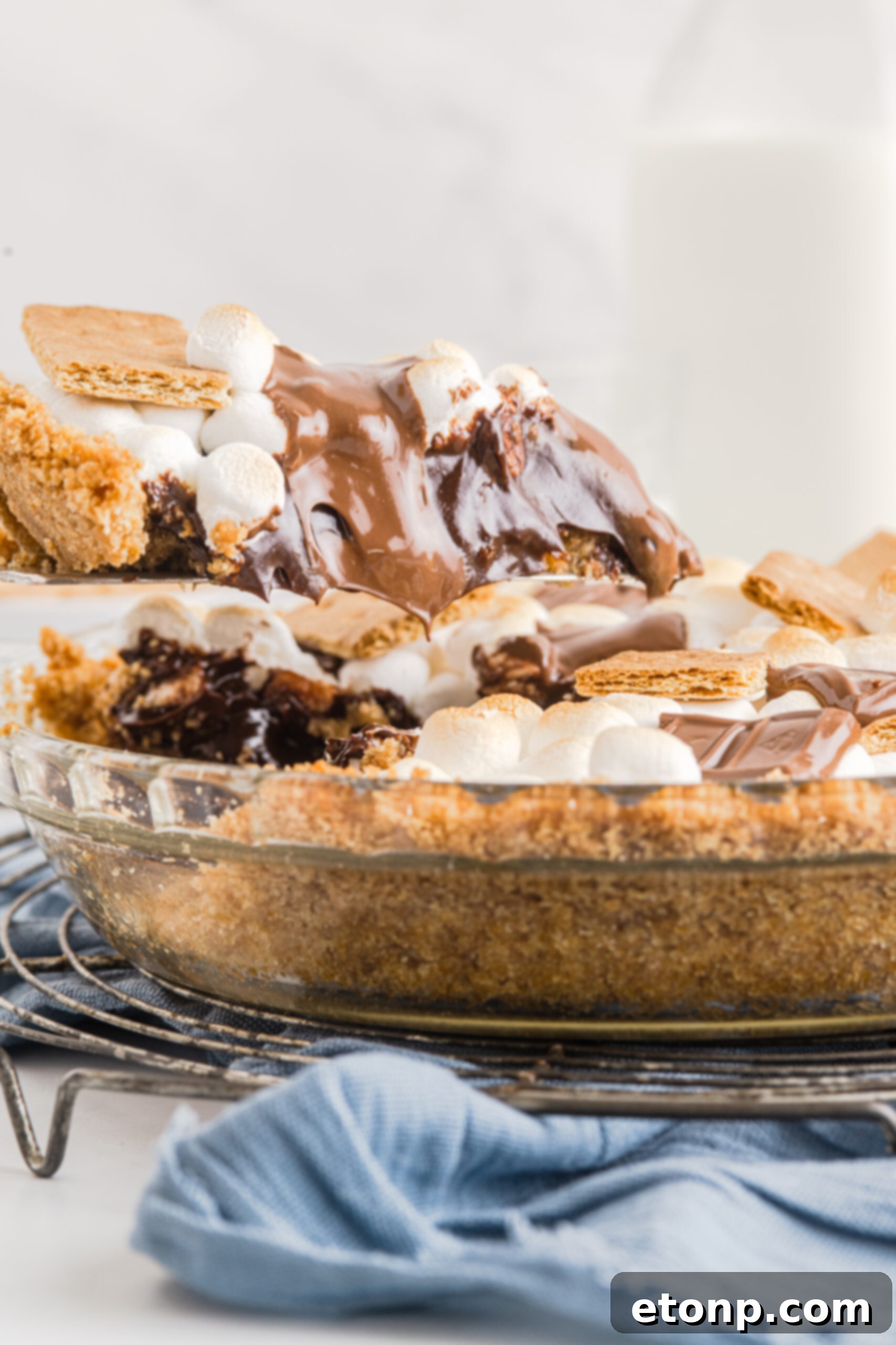 S'mores Pie in a glass baking dish with a slice being lifted out 